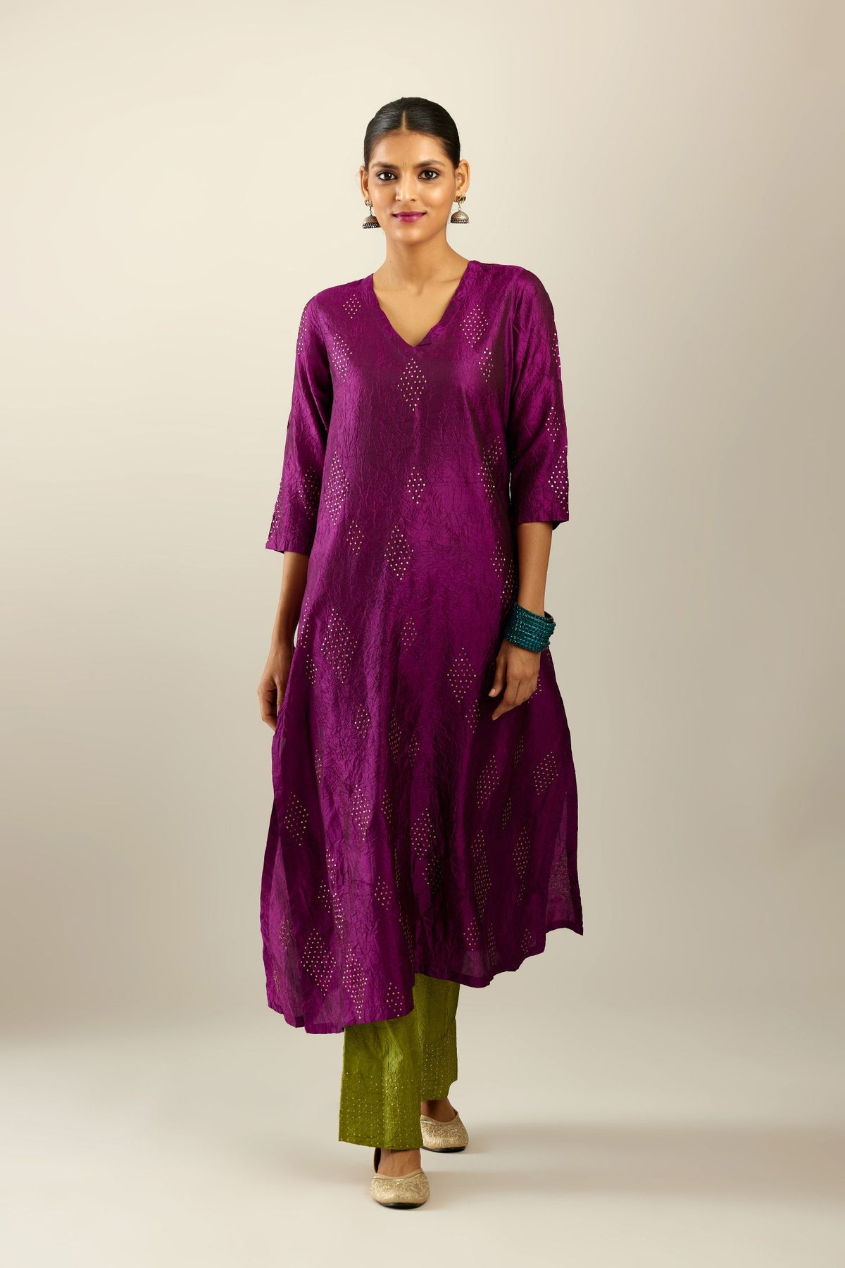 Sangria silk hand crushed A-line kurta set with asymmetric hem, highlighted with all-over gold sequins diamonds.