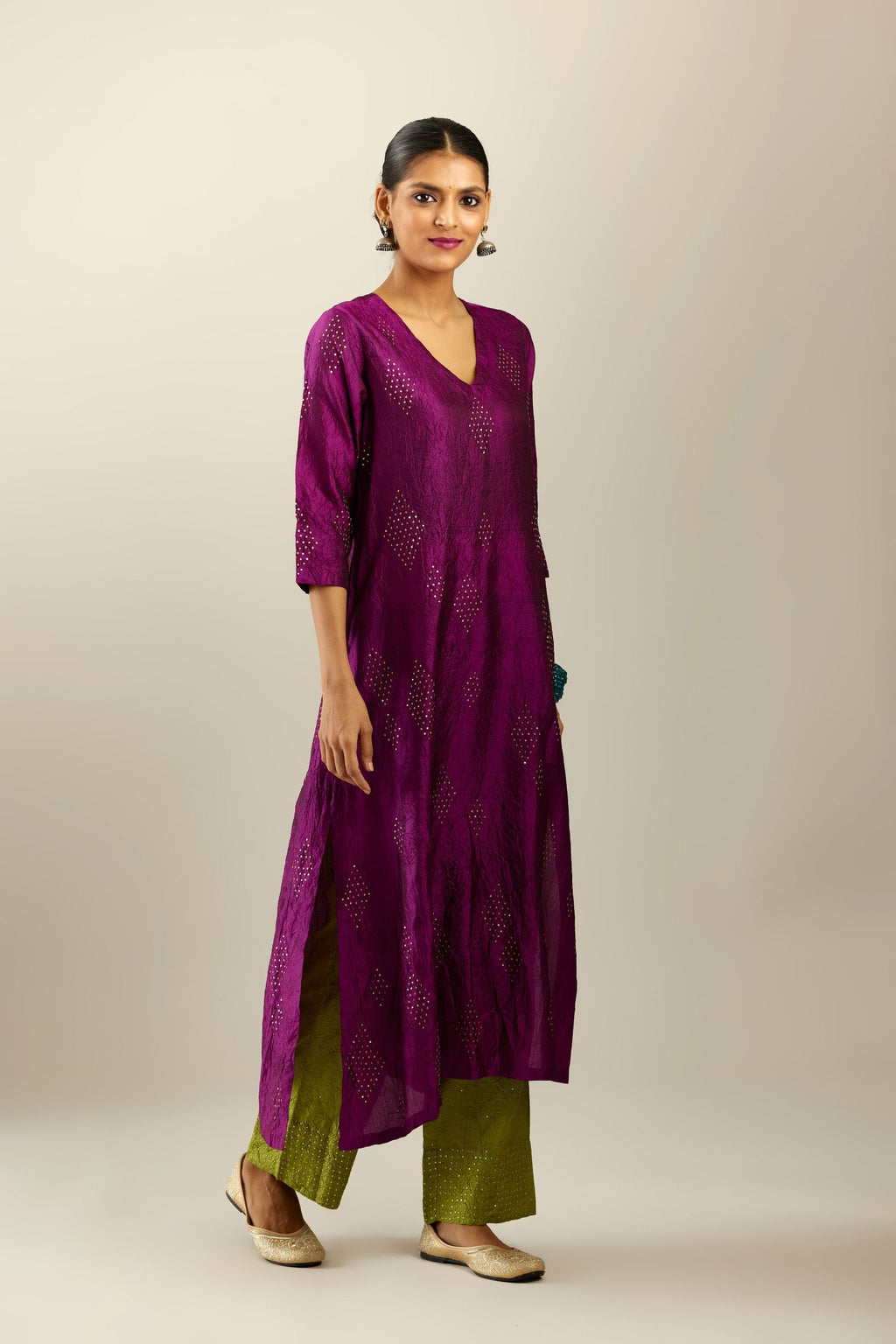 Sangria silk hand crushed A-line kurta set with asymmetric hem, highlighted with all-over gold sequins diamonds.