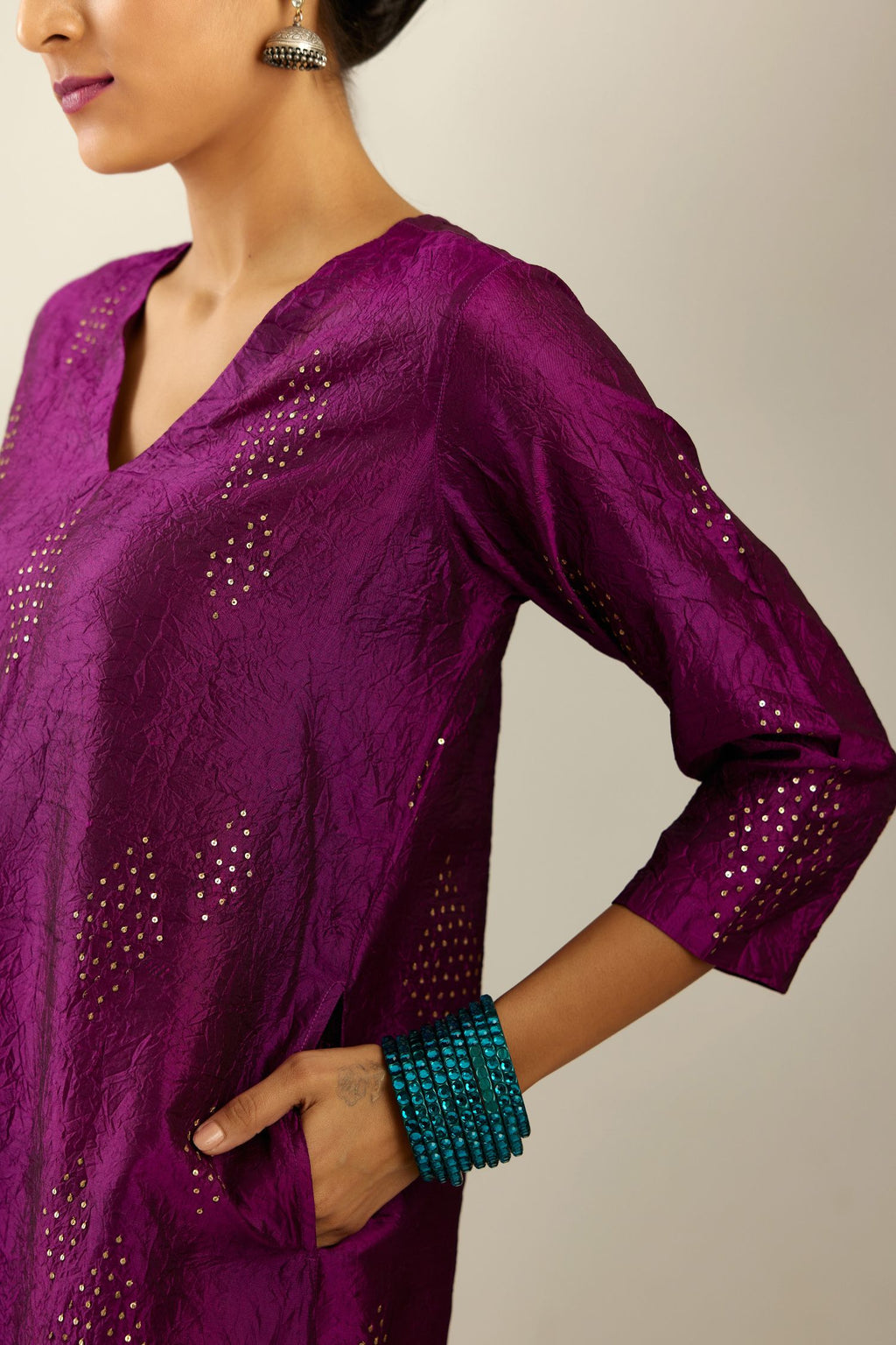 Sangria silk hand crushed A-line kurta set with asymmetric hem, highlighted with all-over gold sequins diamonds.