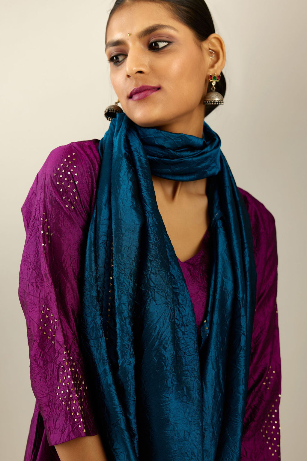 Sangria silk hand crushed A-line kurta set with asymmetric hem, highlighted with all-over gold sequins diamonds.