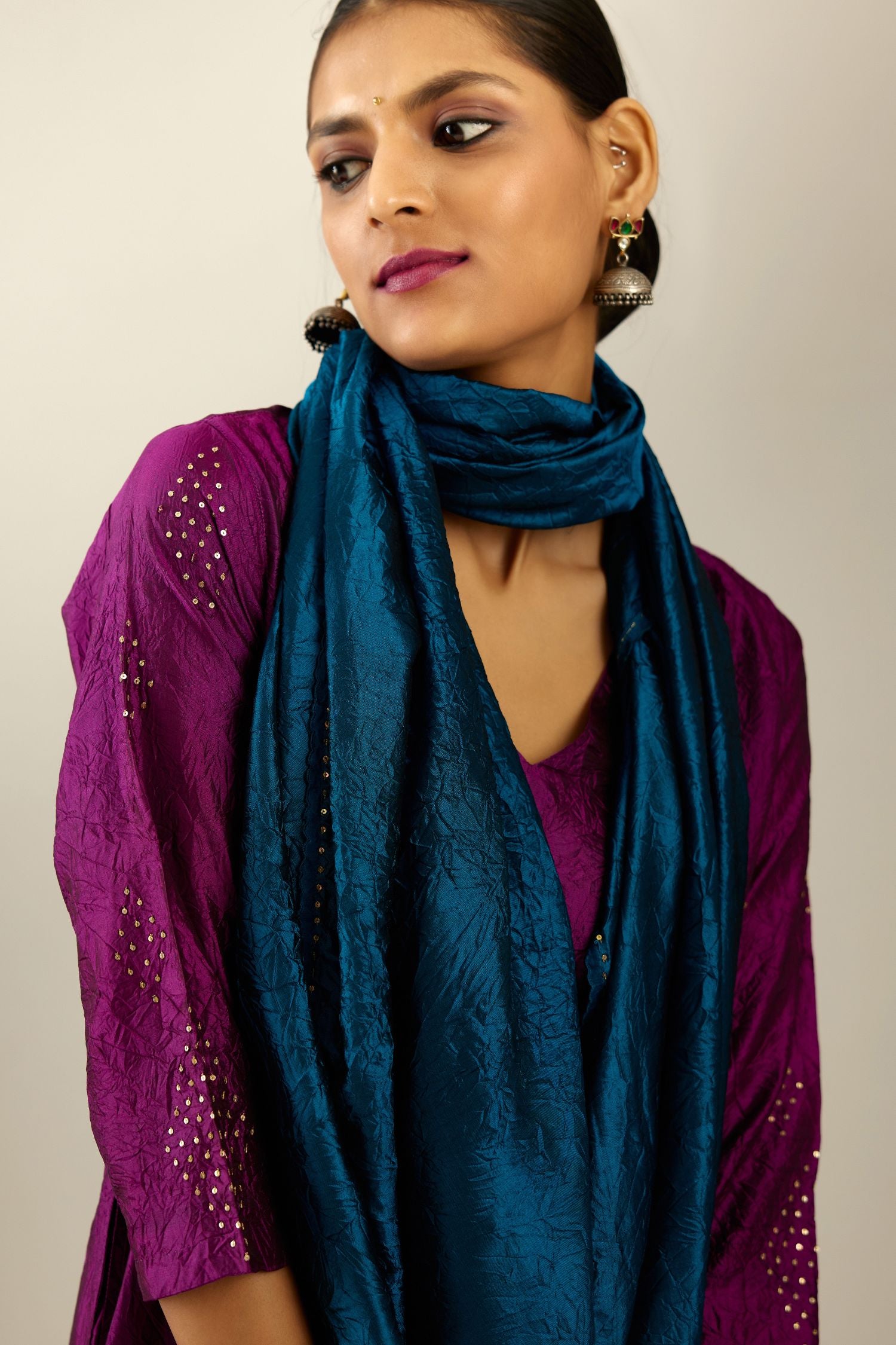 Sangria silk hand crushed A-line kurta set with asymmetric hem, highlighted with all-over gold sequins diamonds.