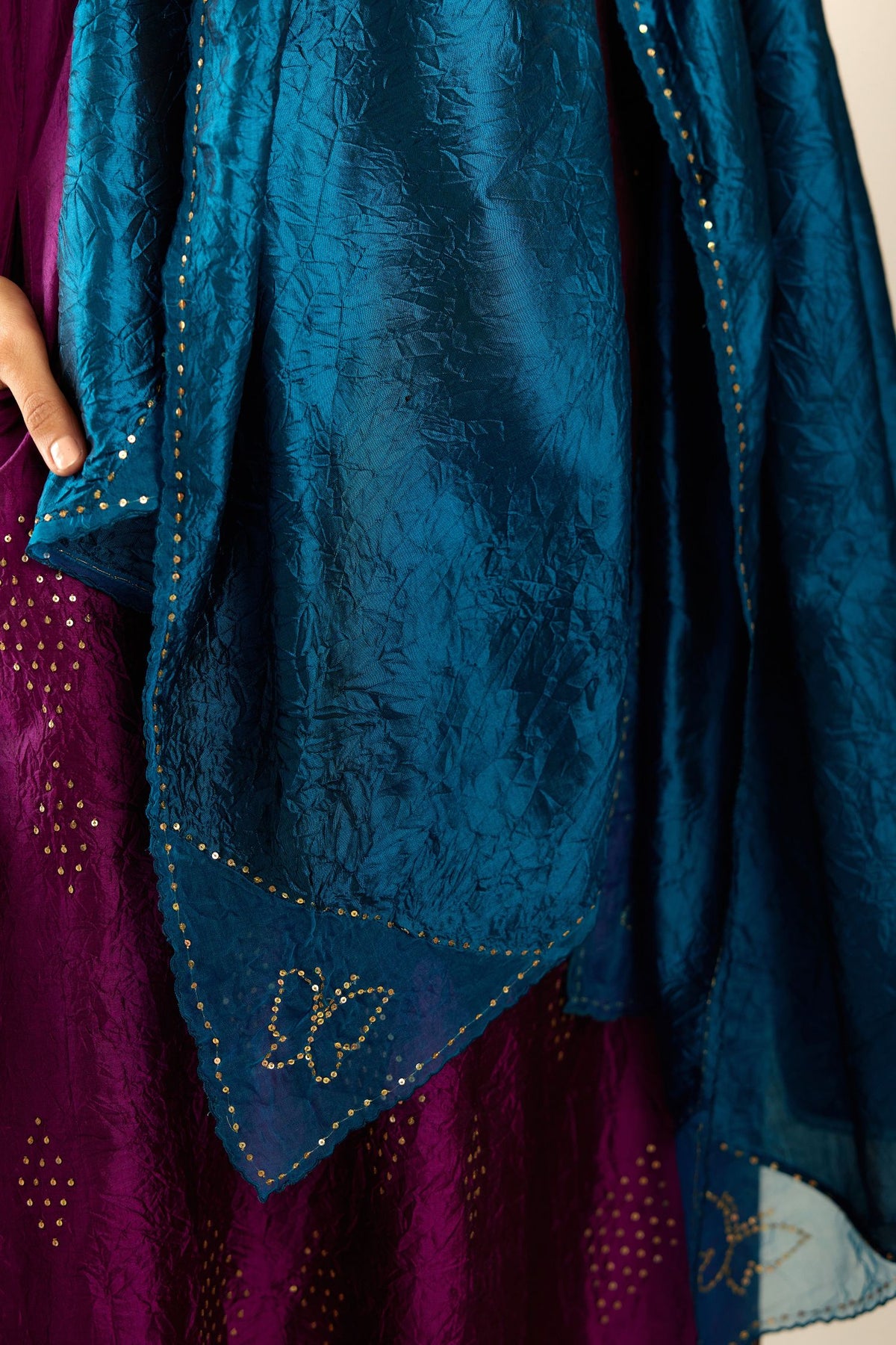 Sangria silk hand crushed A-line kurta set with asymmetric hem, highlighted with all-over gold sequins diamonds.