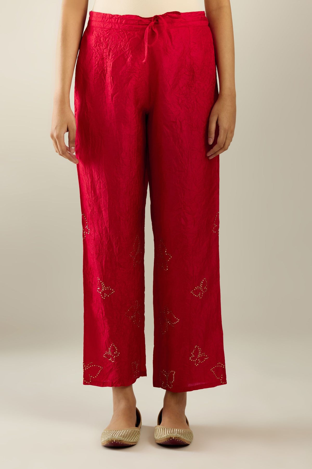 Red silk pants with side pockets and assorted sequined butterflies till mid-calf length.