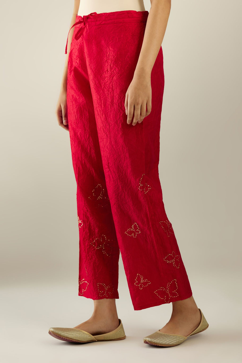 Red silk pants with side pockets and assorted sequined butterflies till mid-calf length.