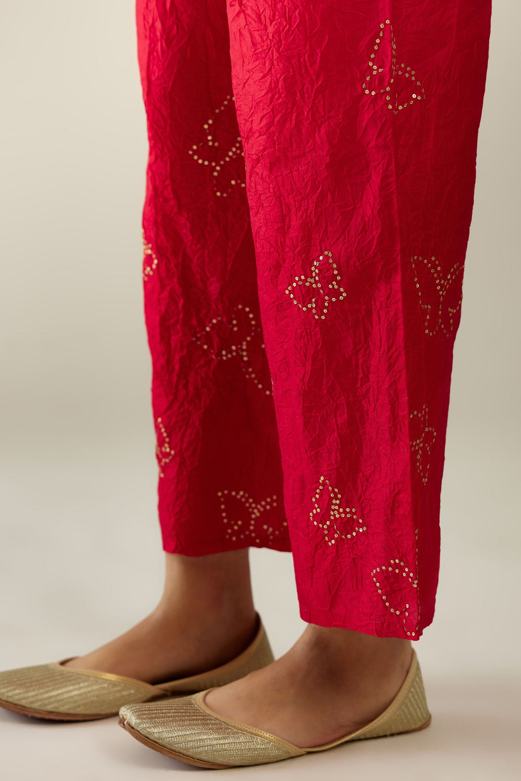 Red silk pants with side pockets and assorted sequined butterflies till mid-calf length.