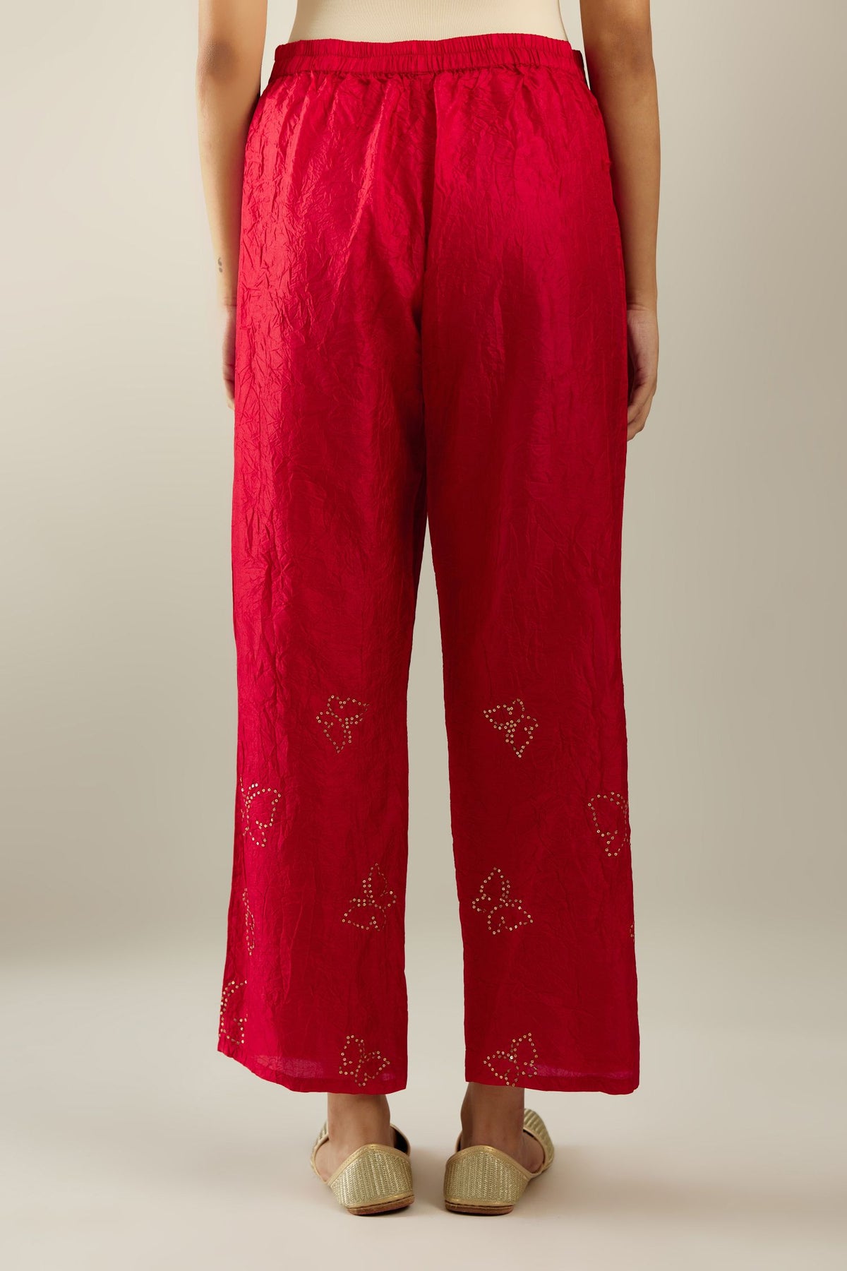 Red silk pants with side pockets and assorted sequined butterflies till mid-calf length.