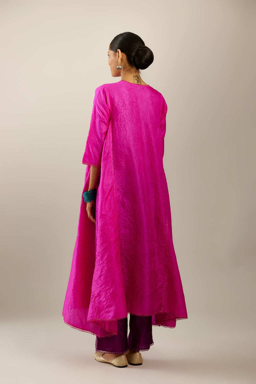 Fiji fuchsia hand crushed silk kurta set with asymmetric hem, highlighted with gold sequins and embroidered scalloped organza at edges.