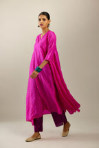 Fiji fuchsia hand crushed silk kurta set with asymmetric hem, highlighted with gold sequins and embroidered scalloped organza at edges.