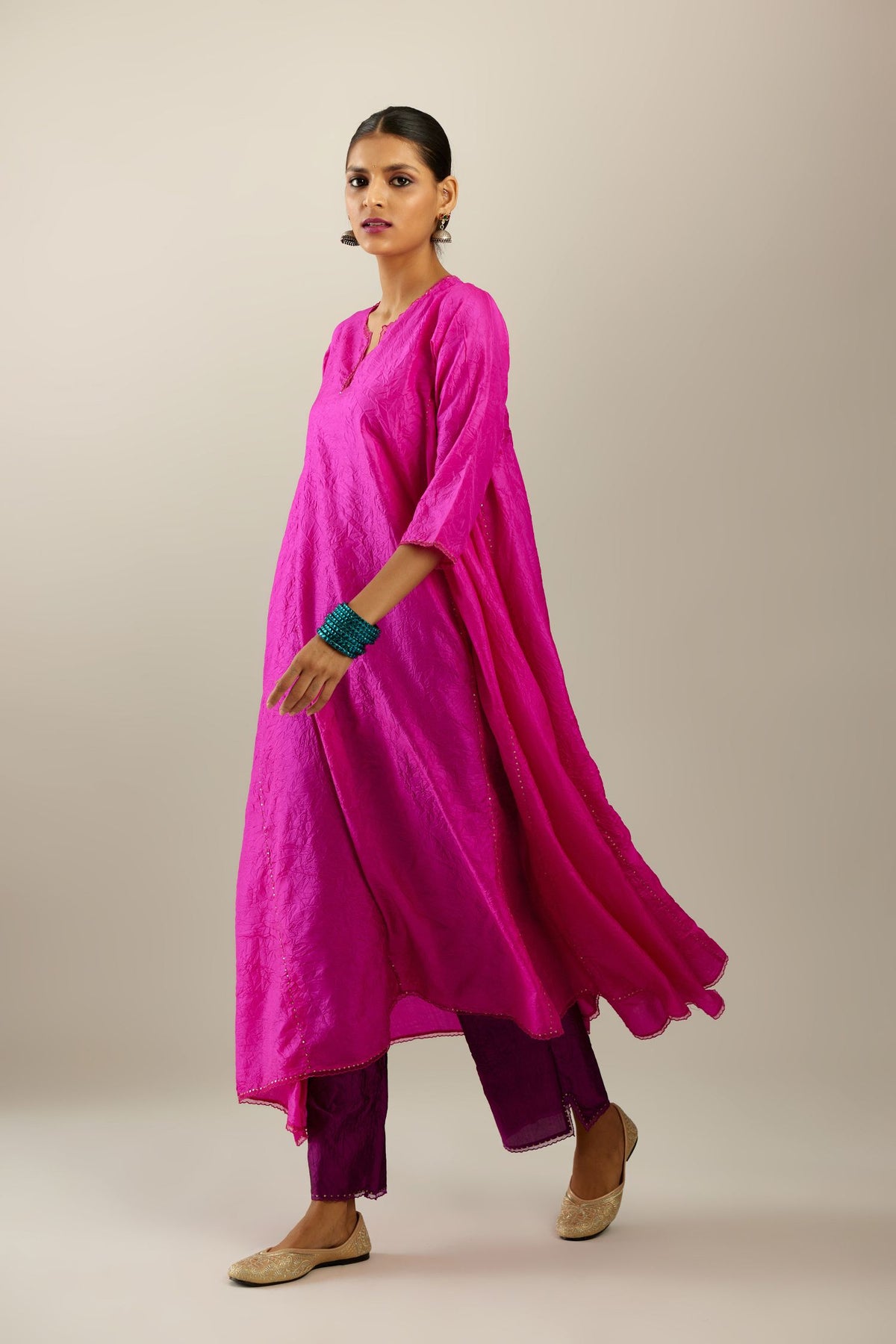 Fiji fuchsia hand crushed silk kurta set with asymmetric hem, highlighted with gold sequins and embroidered scalloped organza at edges.