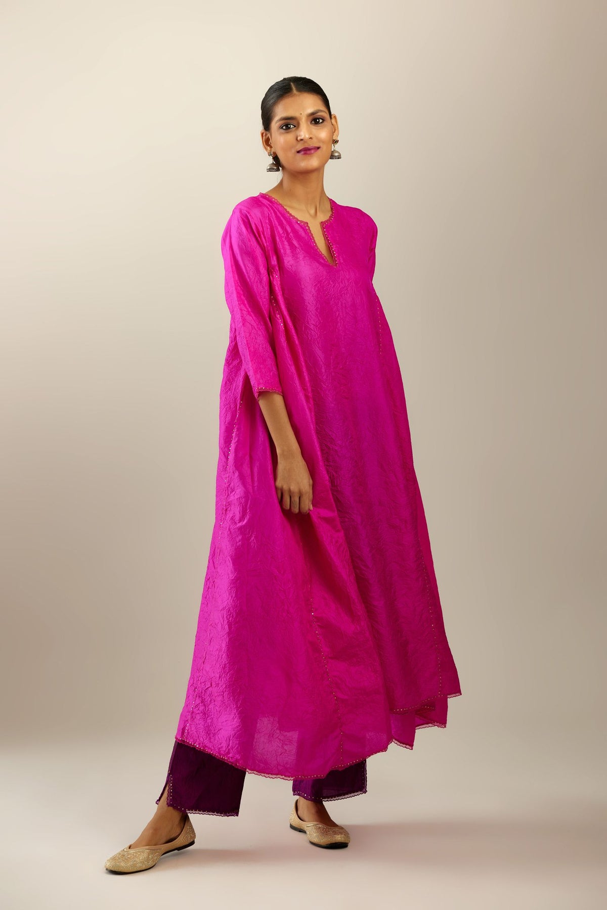 Fiji fuchsia hand crushed silk kurta set with asymmetric hem, highlighted with gold sequins and embroidered scalloped organza at edges.