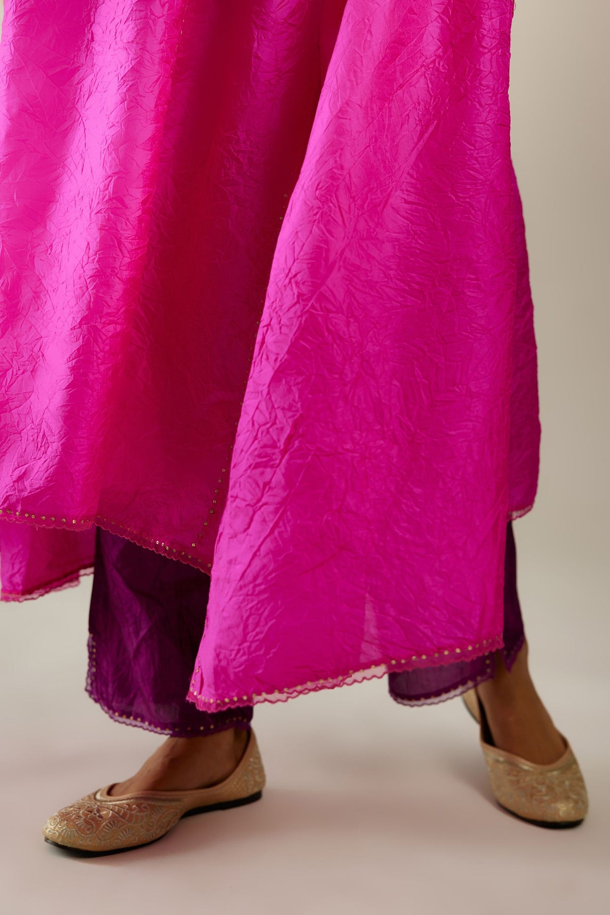 Fiji fuchsia hand crushed silk kurta set with asymmetric hem, highlighted with gold sequins and embroidered scalloped organza at edges.
