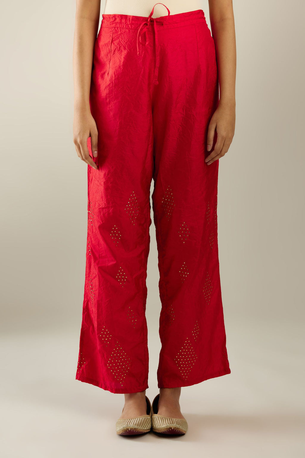 Red hand crushed pure silk straight pants with assorted diamond shape golden sequins work till knee length and side pockets.