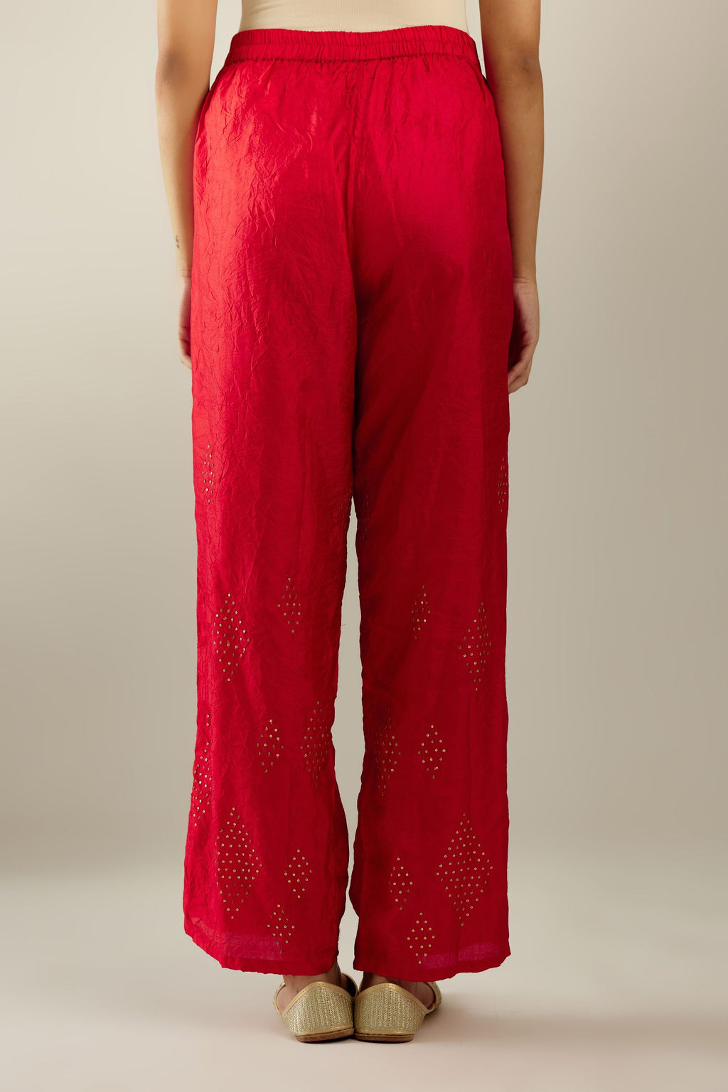Red hand crushed pure silk straight pants with assorted diamond shape golden sequins work till knee length and side pockets.
