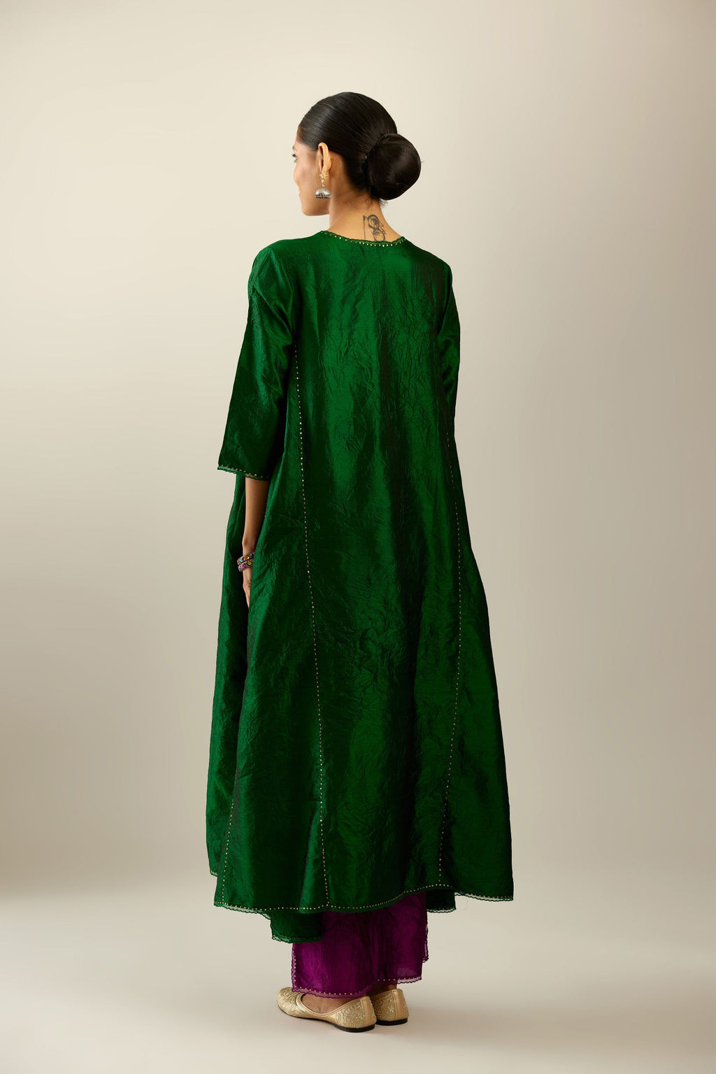 Dark green hand crushed silk kurta set with asymmetric hem, highlighted with gold sequins and embroidered scalloped organza at edges.
