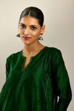 Dark green hand crushed silk kurta set with asymmetric hem, highlighted with gold sequins and embroidered scalloped organza at edges.