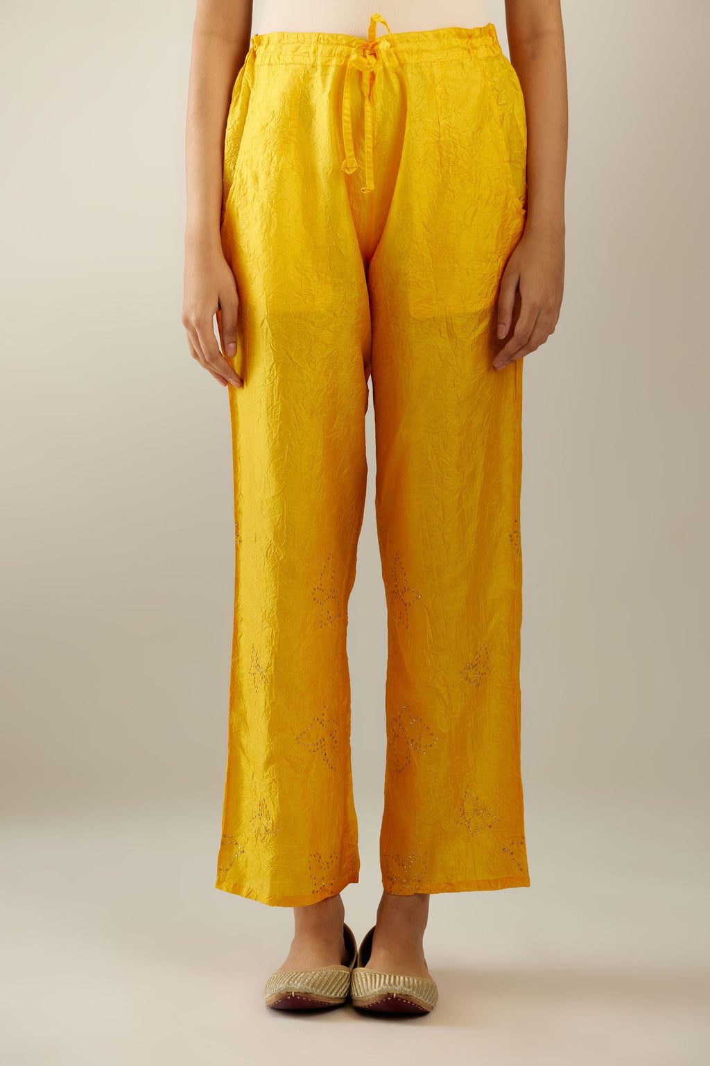 Deep yellow crushed silk pants with side pockets and assorted sequined butterflies till mid-calf length.
