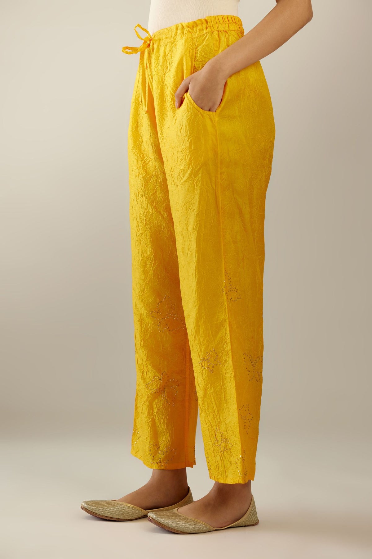 Deep yellow crushed silk pants with side pockets and assorted sequined butterflies till mid-calf length.