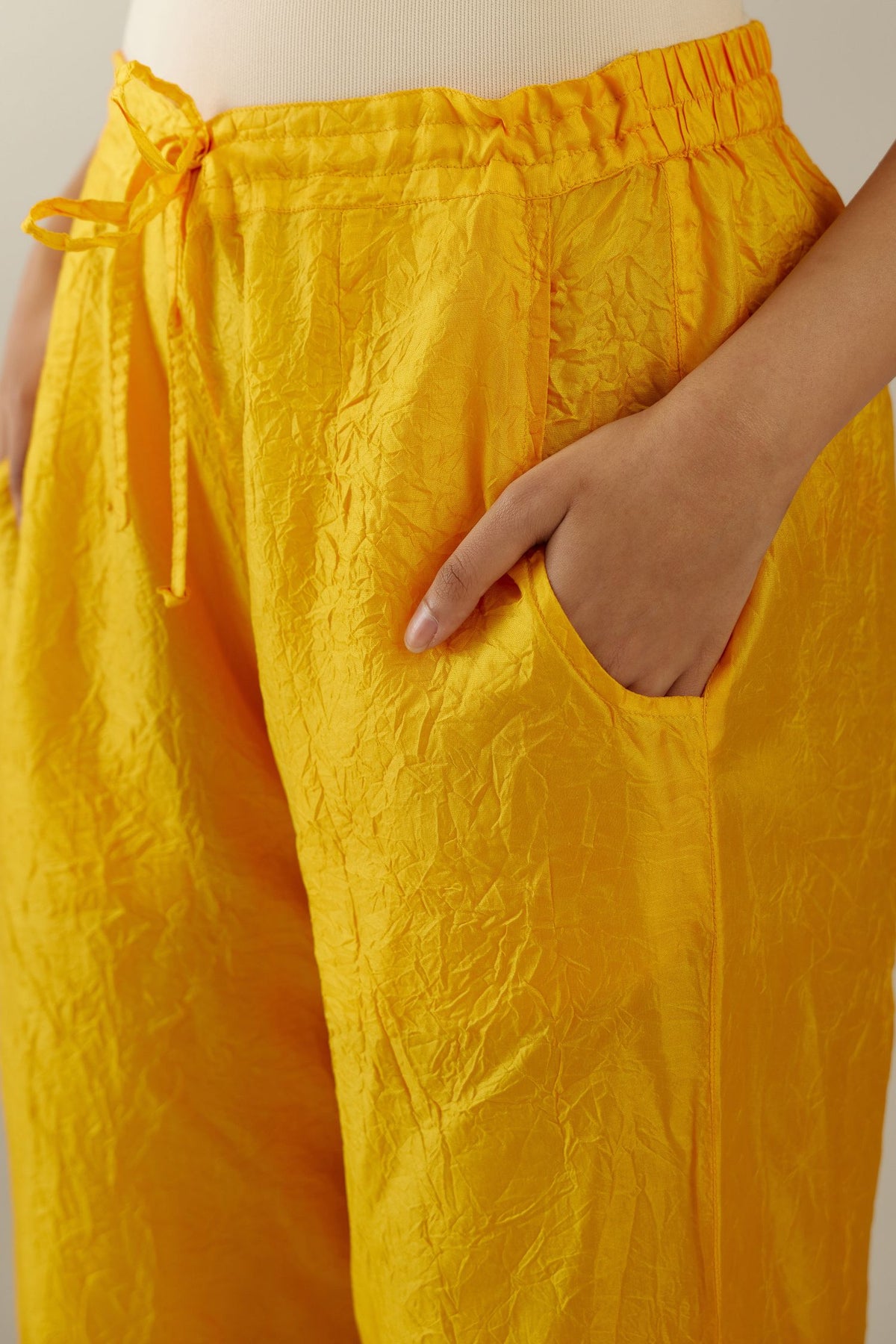 Deep yellow crushed silk pants with side pockets and assorted sequined butterflies till mid-calf length.