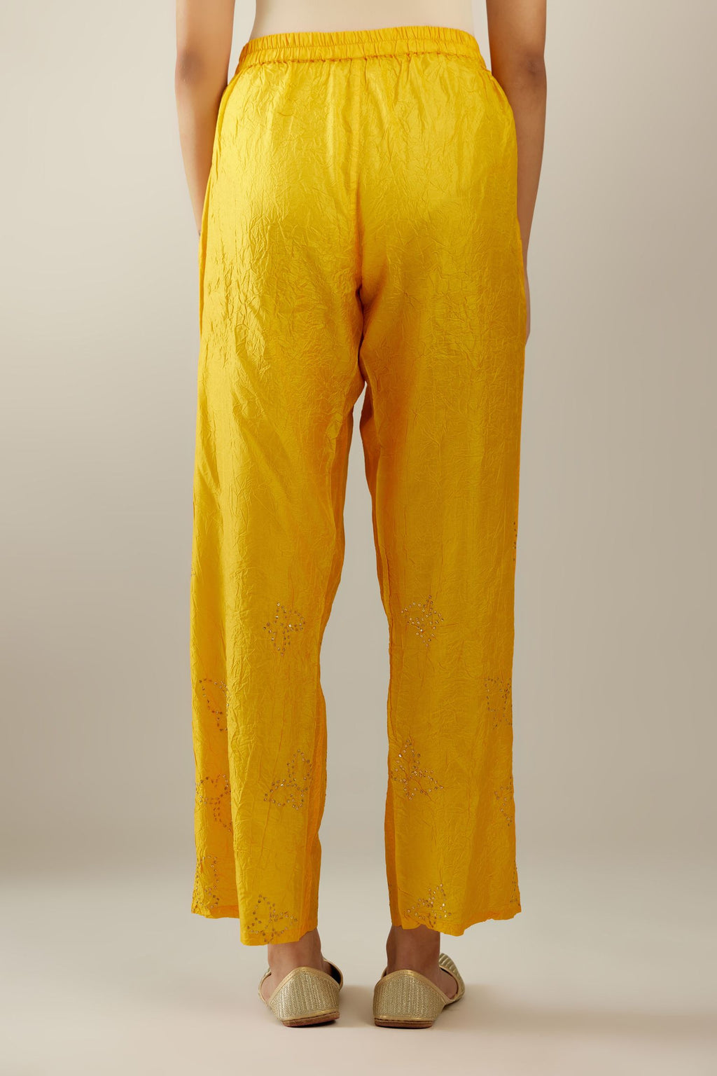 Deep yellow crushed silk pants with side pockets and assorted sequined butterflies till mid-calf length.