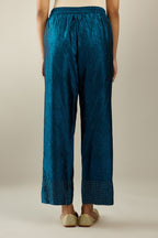 Dark teal hand crushed silk straight pants detailed with gold sequins at hem and a single sequin buti is sprayed all over the pants and side pockets