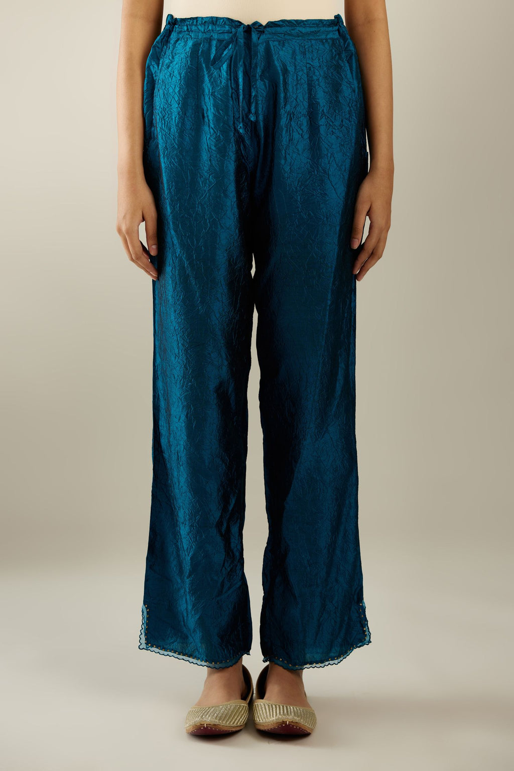 Dark teal hand crushed silk straight pants with scalloped and embroidered organza at edges and detailed with a single line of sequins at hem