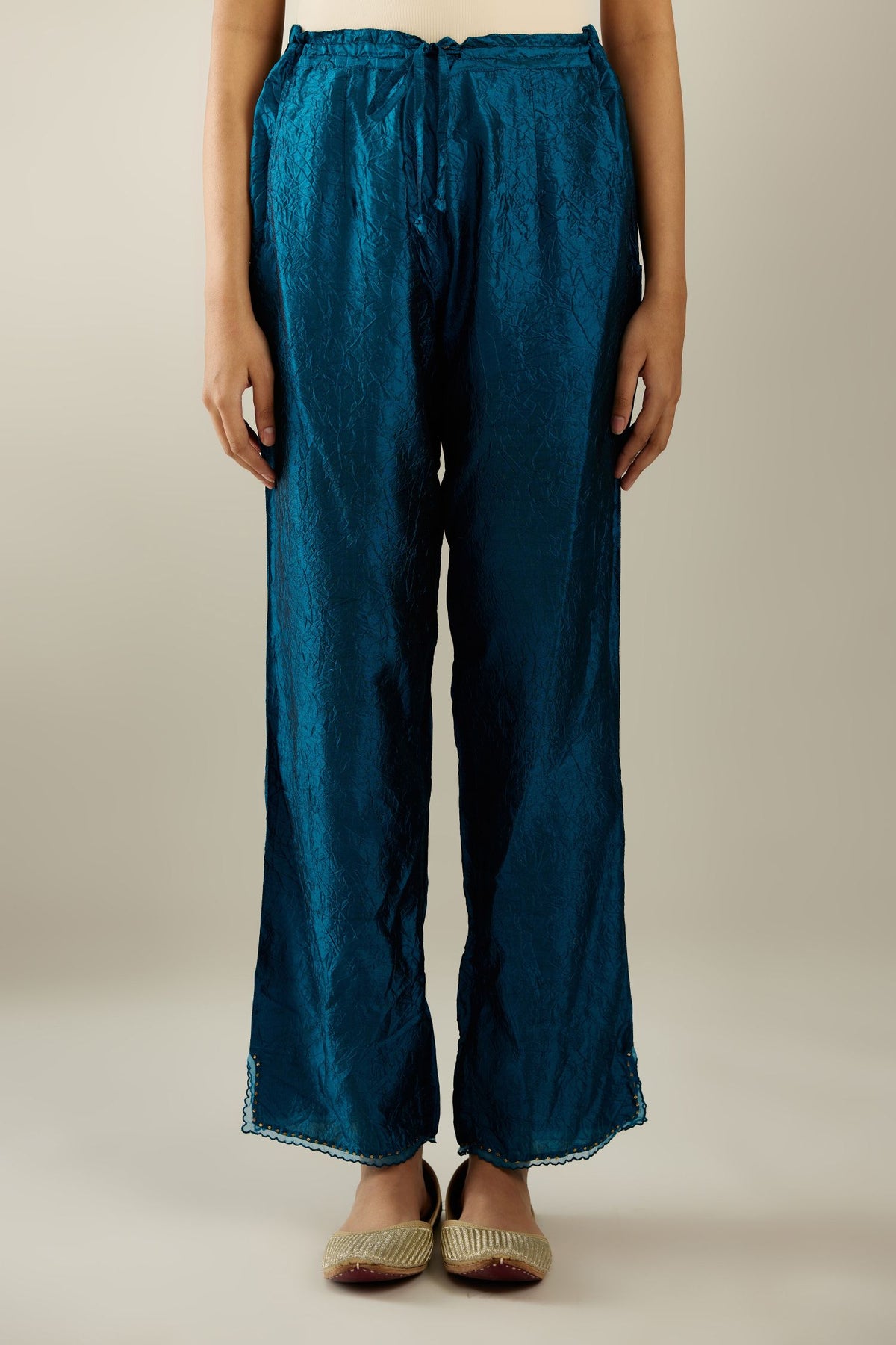 Dark teal hand crushed silk straight pants with scalloped and embroidered organza at edges and detailed with a single line of sequins at hem