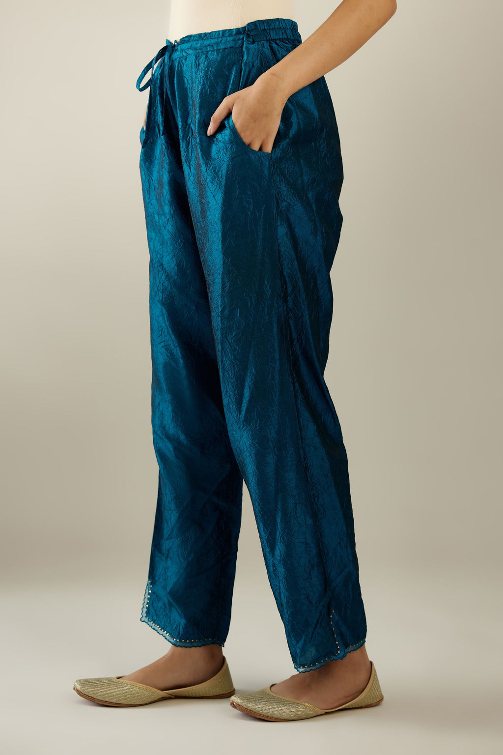 Dark teal hand crushed silk straight pants with scalloped and embroidered organza at edges and detailed with a single line of sequins at hem