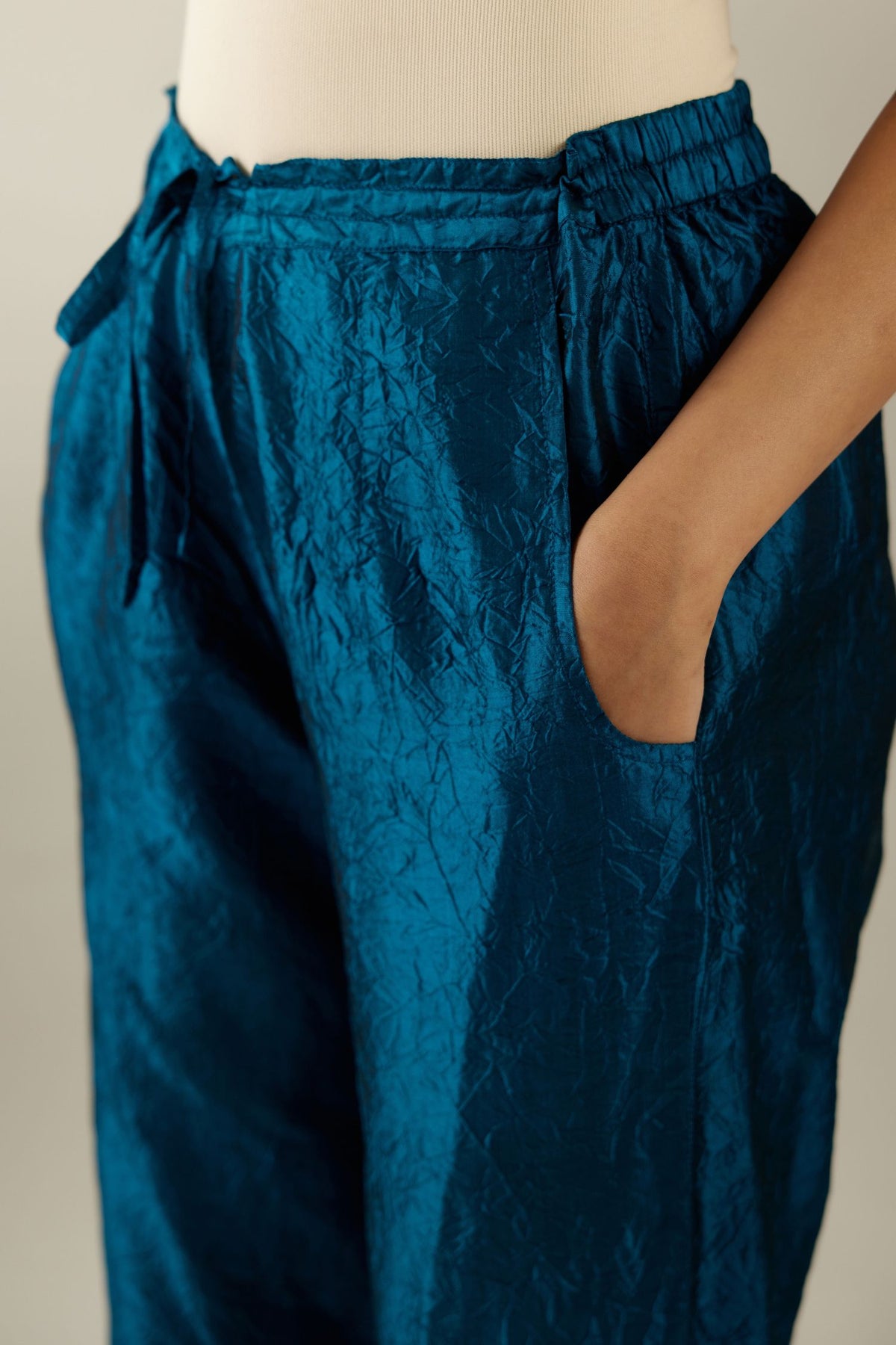 Dark teal hand crushed silk straight pants with scalloped and embroidered organza at edges and detailed with a single line of sequins at hem