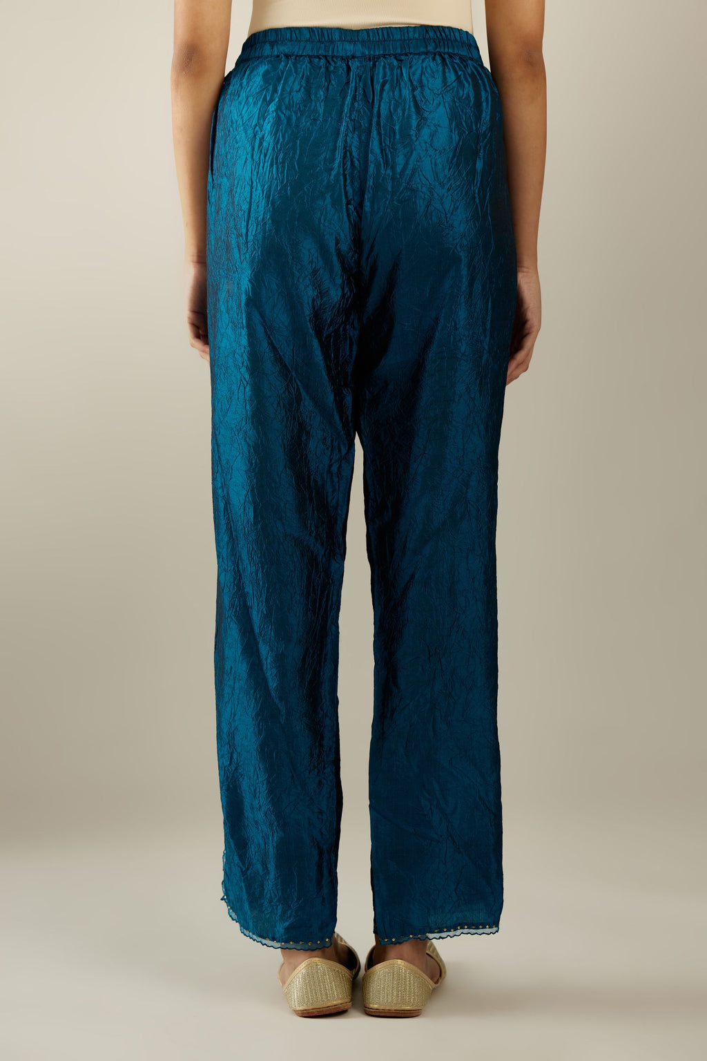 Dark teal hand crushed silk straight pants with scalloped and embroidered organza at edges and detailed with a single line of sequins at hem