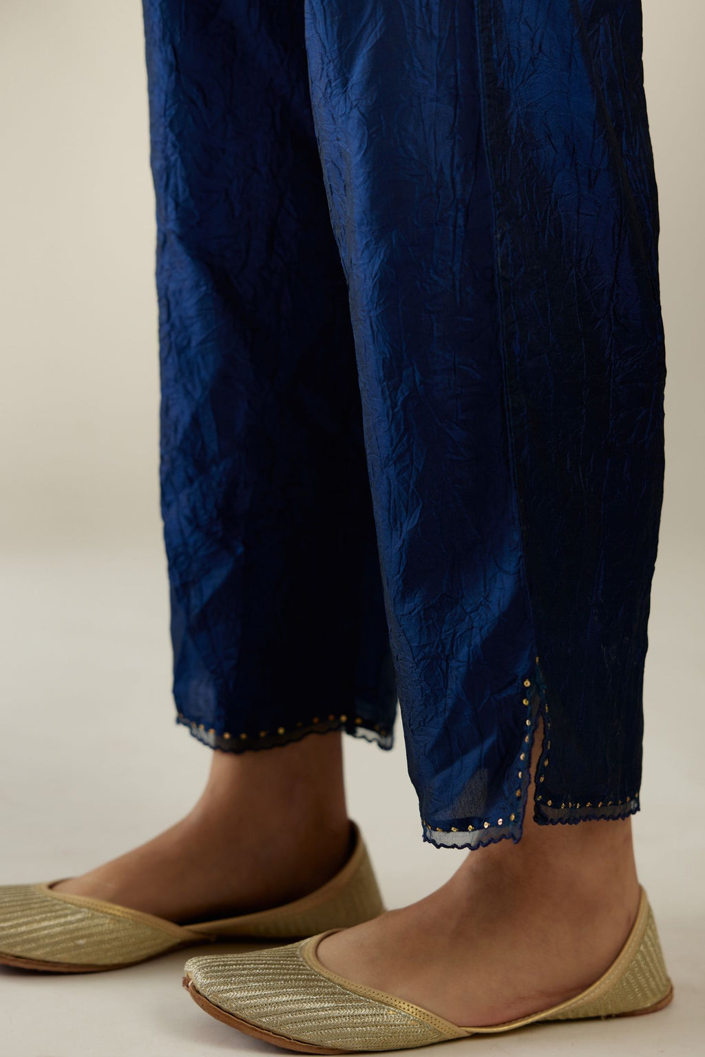 Navy blue hand crushed silk straight pants with scalloped and embroidered organza at edges and detailed with a single line of sequins at hem