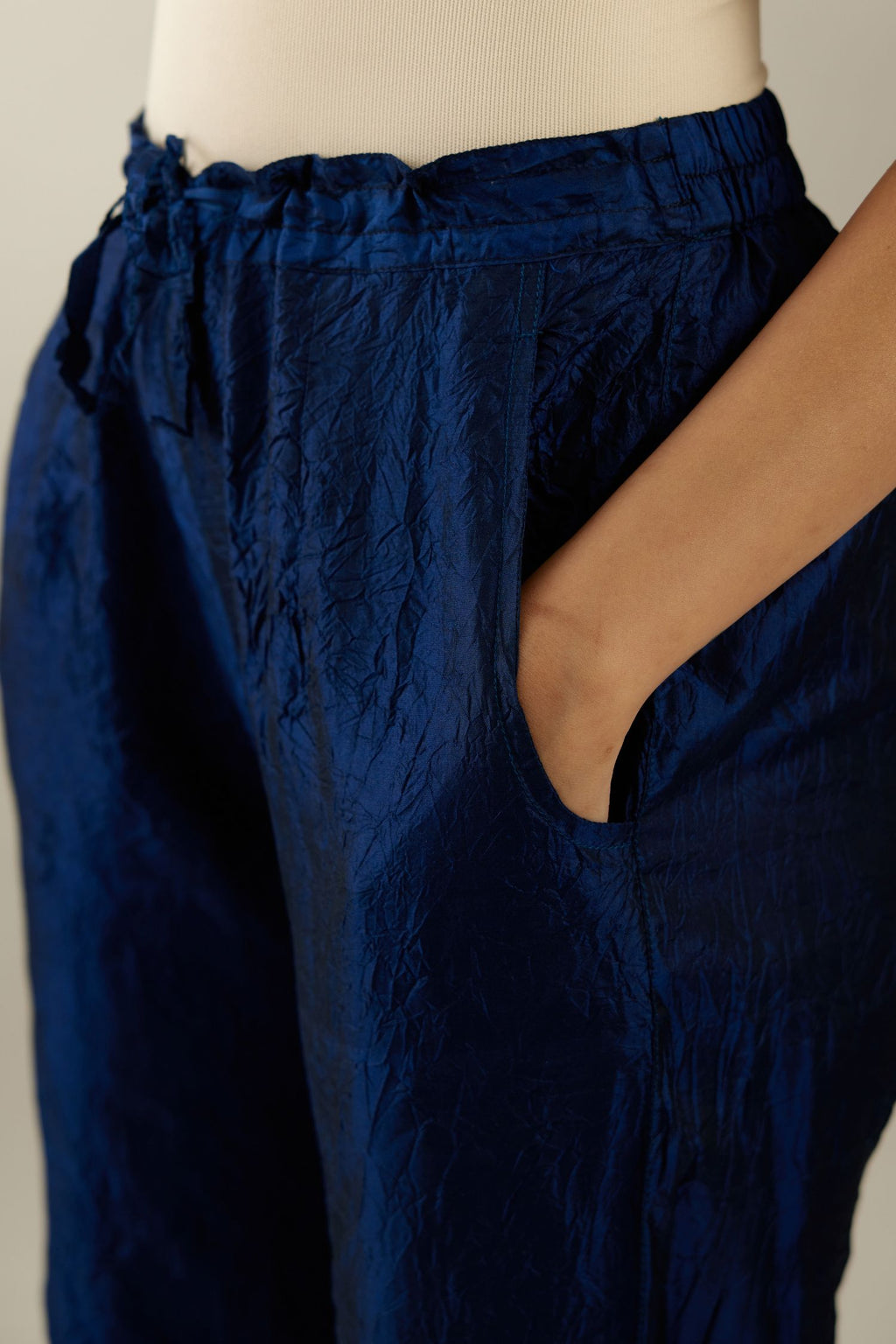 Navy blue hand crushed silk straight pants with scalloped and embroidered organza at edges and detailed with a single line of sequins at hem