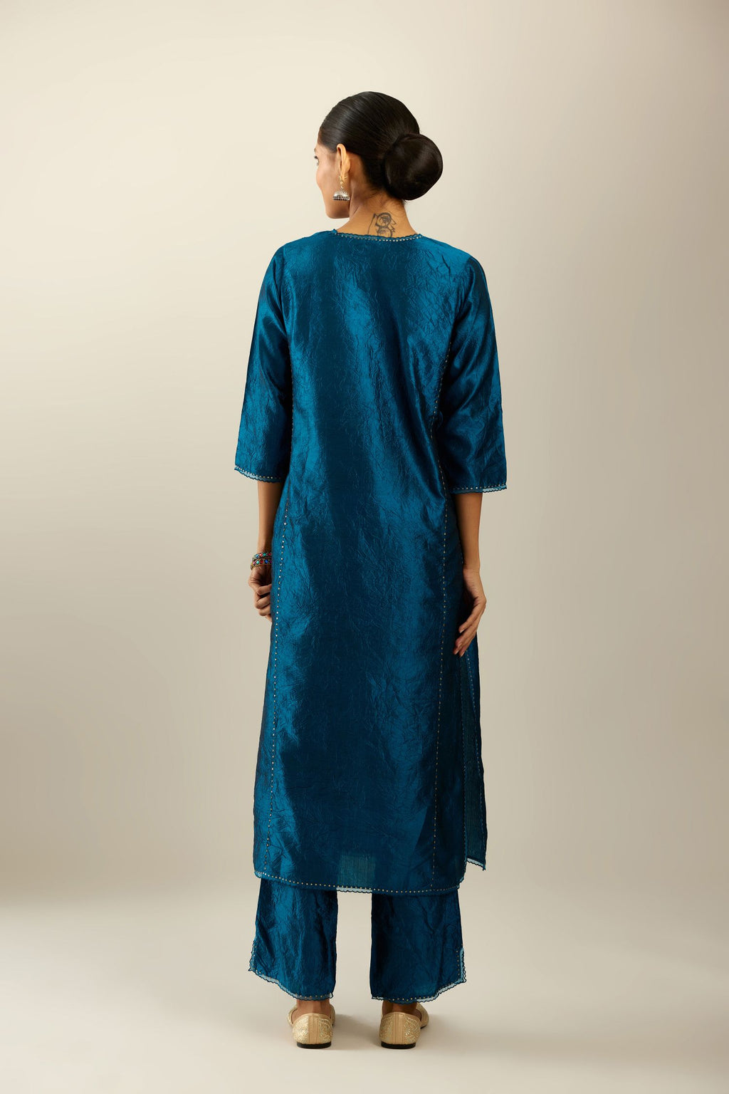 Silk hand crushed kurta set with concealed button placket neckline, highlighted with sequins and scalloped organza at edges.