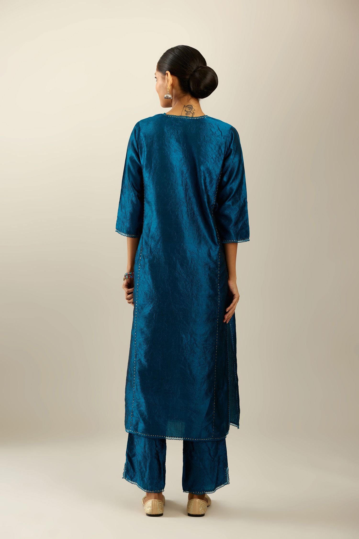 Silk hand crushed kurta set with concealed button placket neckline, highlighted with sequins and scalloped organza at edges.