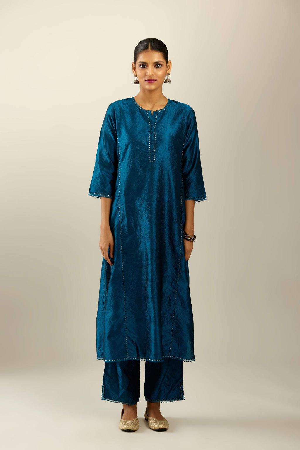 Silk hand crushed kurta set with concealed button placket neckline, highlighted with sequins and scalloped organza at edges.