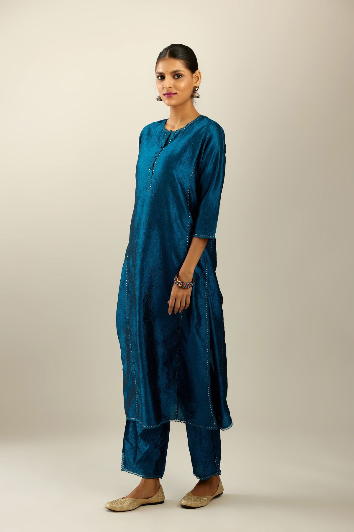 Silk hand crushed kurta set with concealed button placket neckline, highlighted with sequins and scalloped organza at edges.