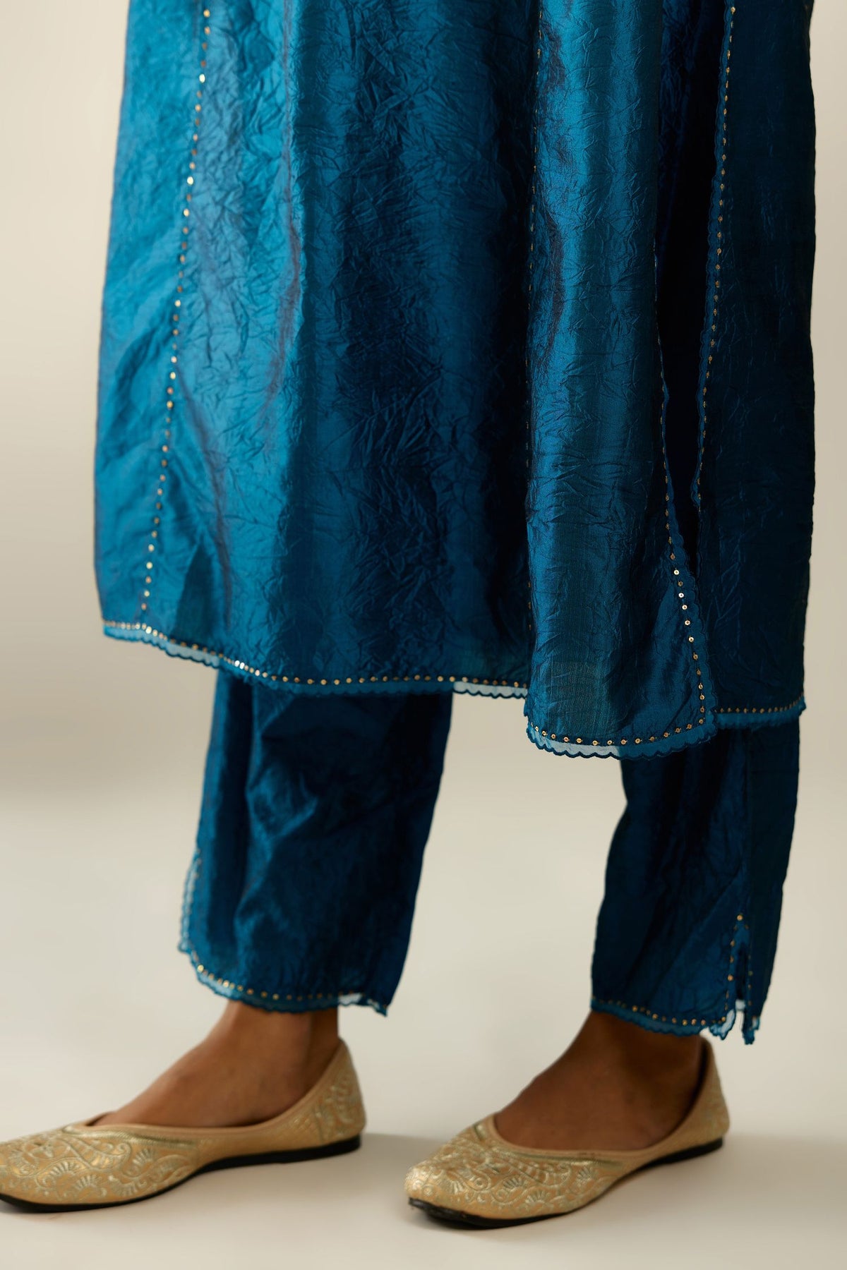 Silk hand crushed kurta set with concealed button placket neckline, highlighted with sequins and scalloped organza at edges.
