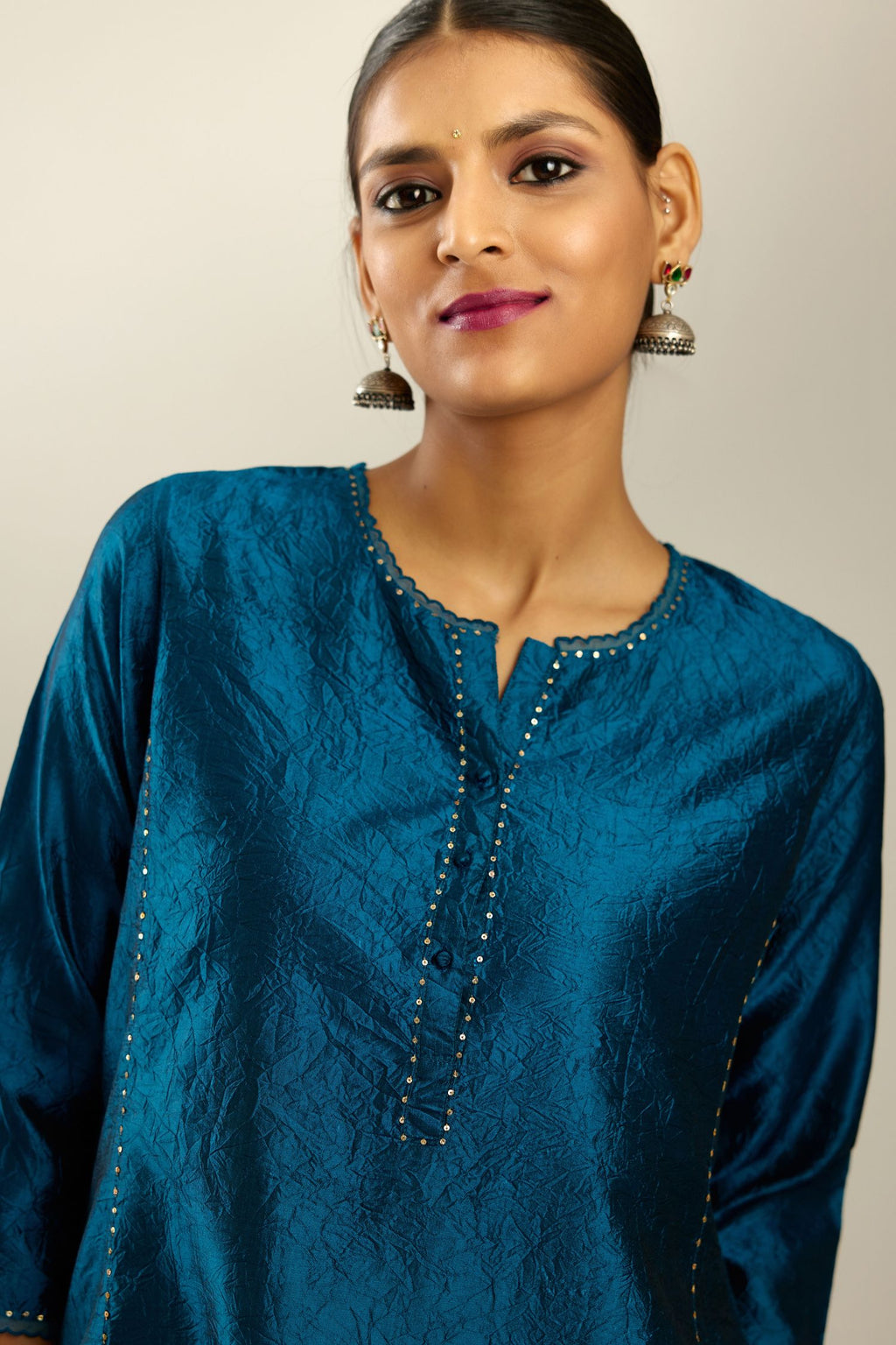 Silk hand crushed kurta set with concealed button placket neckline, highlighted with sequins and scalloped organza at edges.