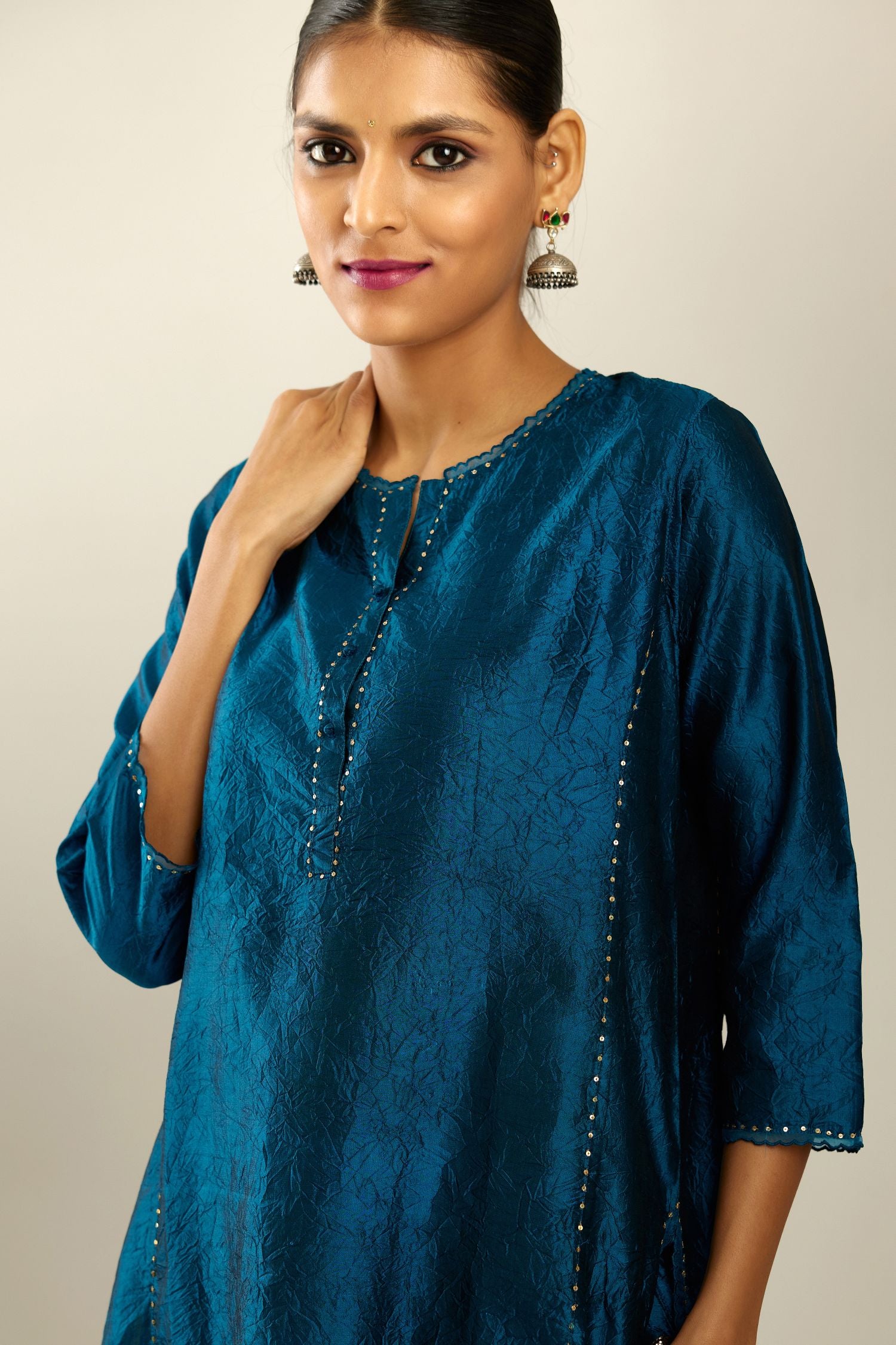 Silk hand crushed kurta set with concealed button placket neckline, highlighted with sequins and scalloped organza at edges.