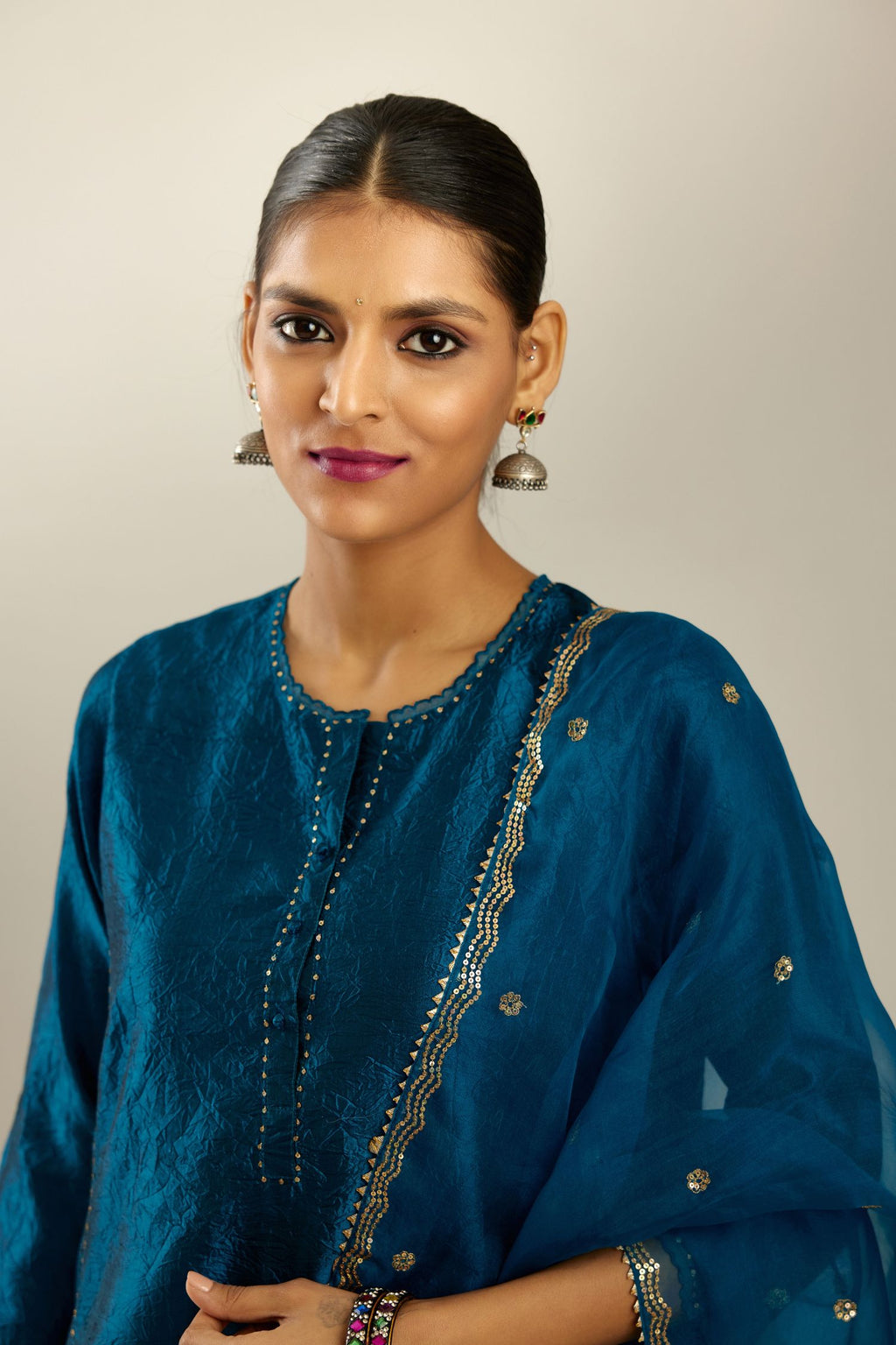 Silk hand crushed kurta set with concealed button placket neckline, highlighted with sequins and scalloped organza at edges.
