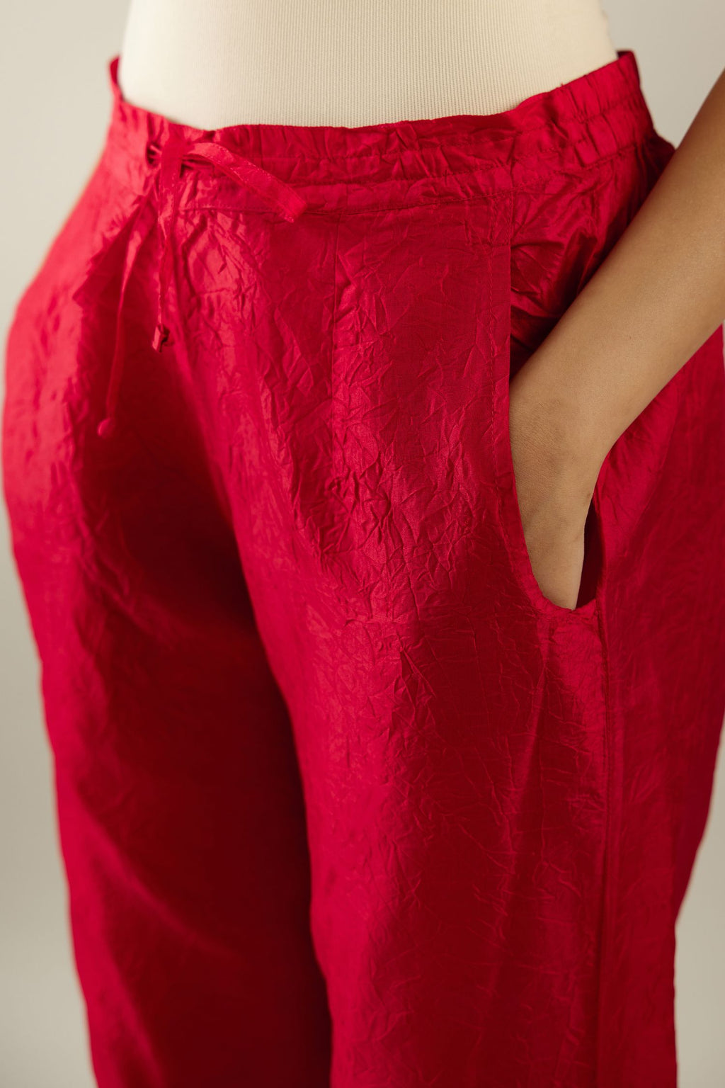 Red hand crushed silk straight pants with scalloped and embroidered organza at edges and detailed with a single line of sequins at hem