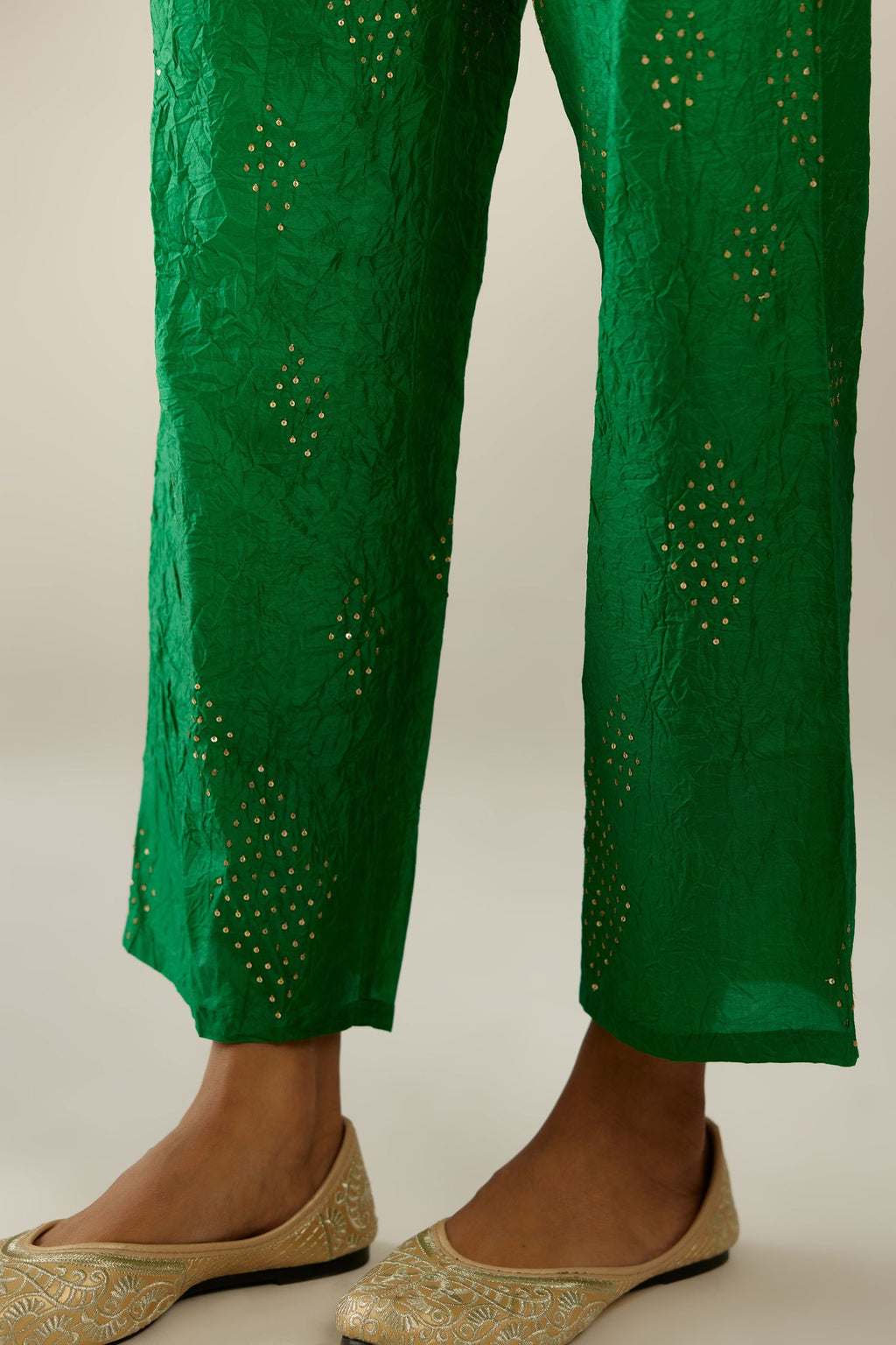 Grass green hand crushed pure silk straight pants with assorted diamond shape golden sequins work till knee length and side pockets.