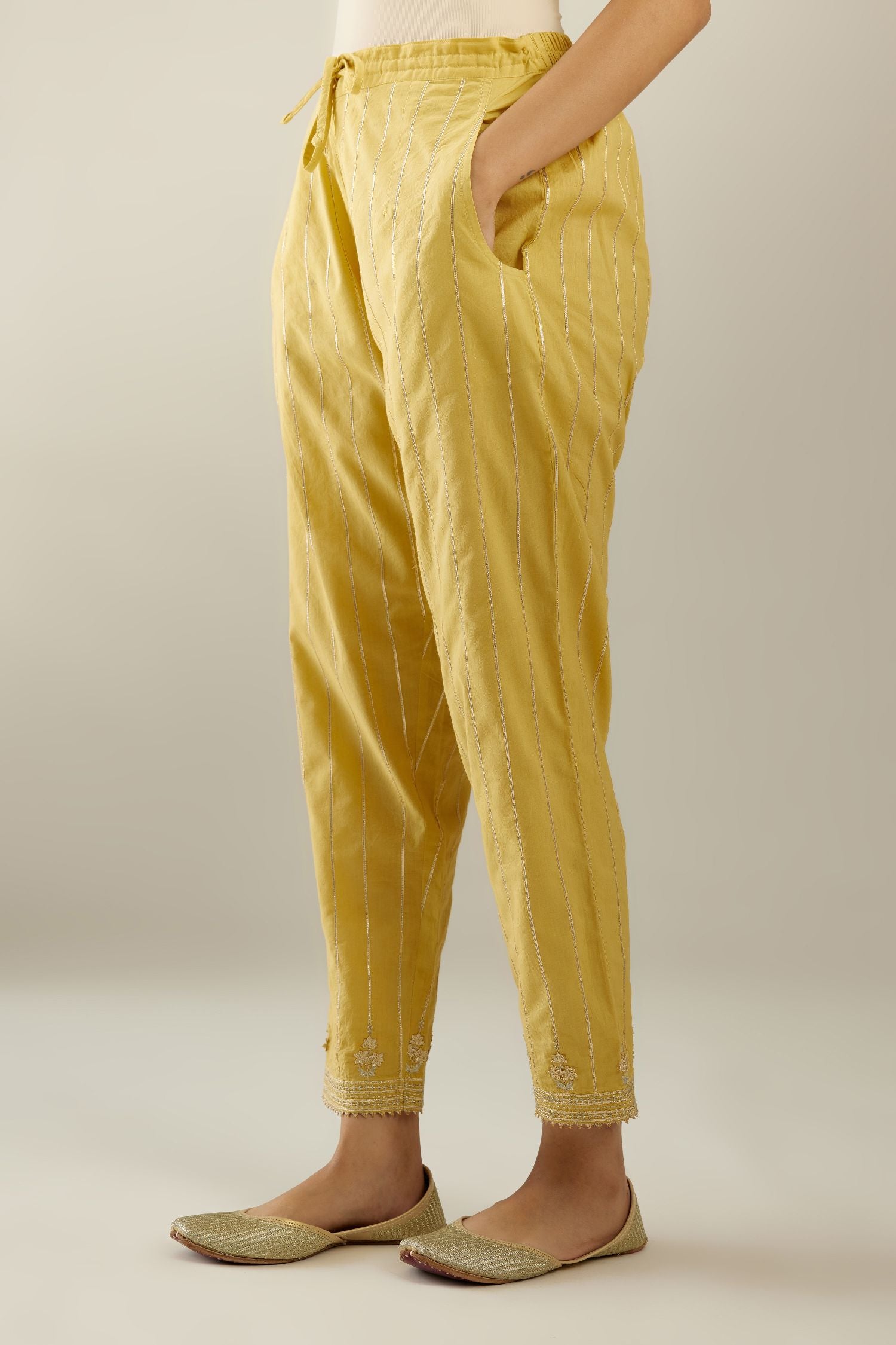 Yellow cotton straight pants with all-over gold gota lines and zari embroidery at hem.