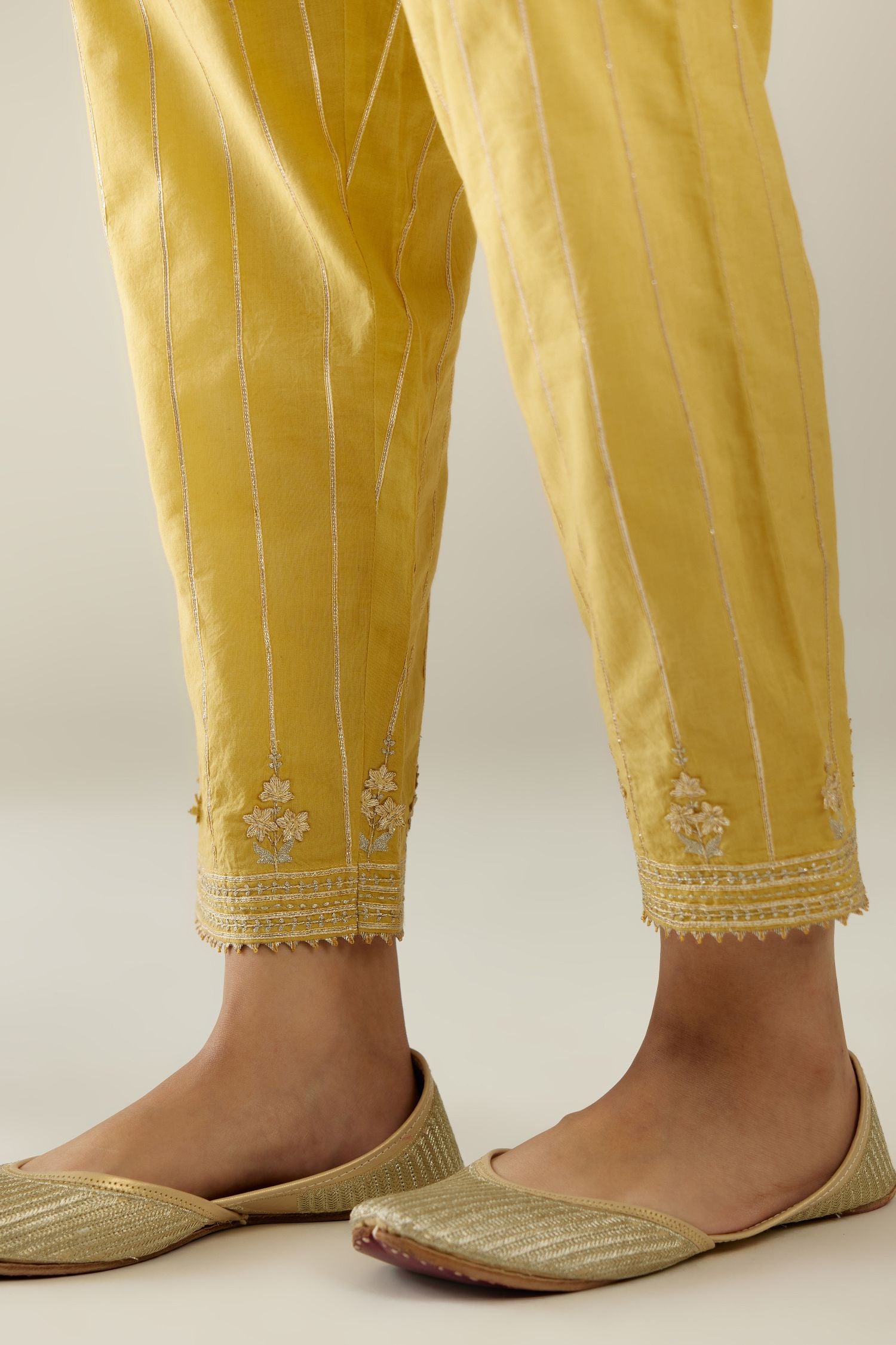 Yellow cotton straight pants with all-over gold gota lines and zari embroidery at hem.