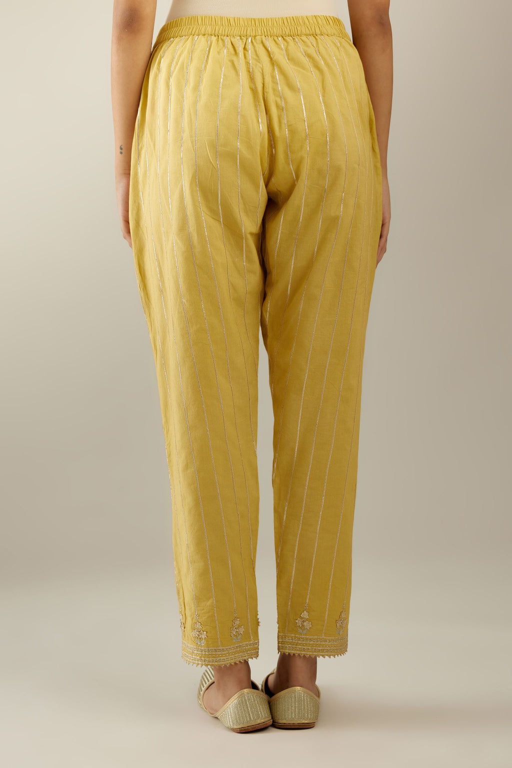 Yellow cotton straight pants with all-over gold gota lines and zari embroidery at hem.