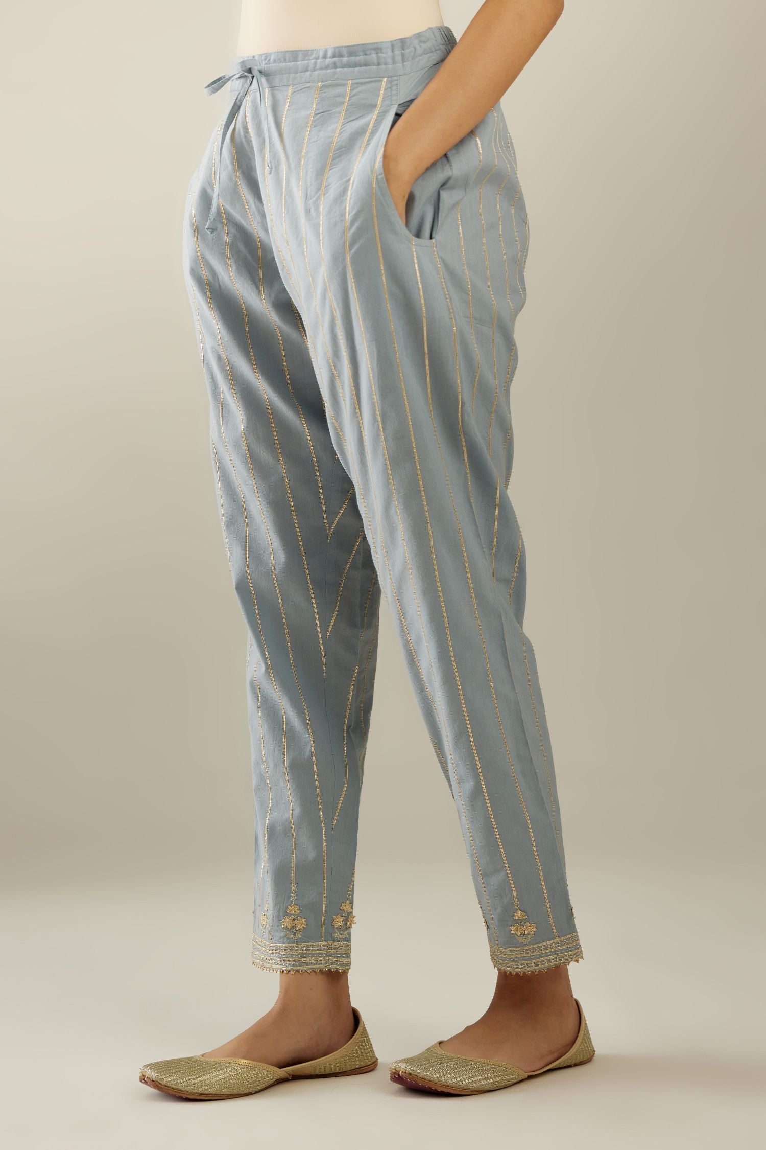 Blue cotton straight pants with all-over gold gota lines and zari embroidery at hem.