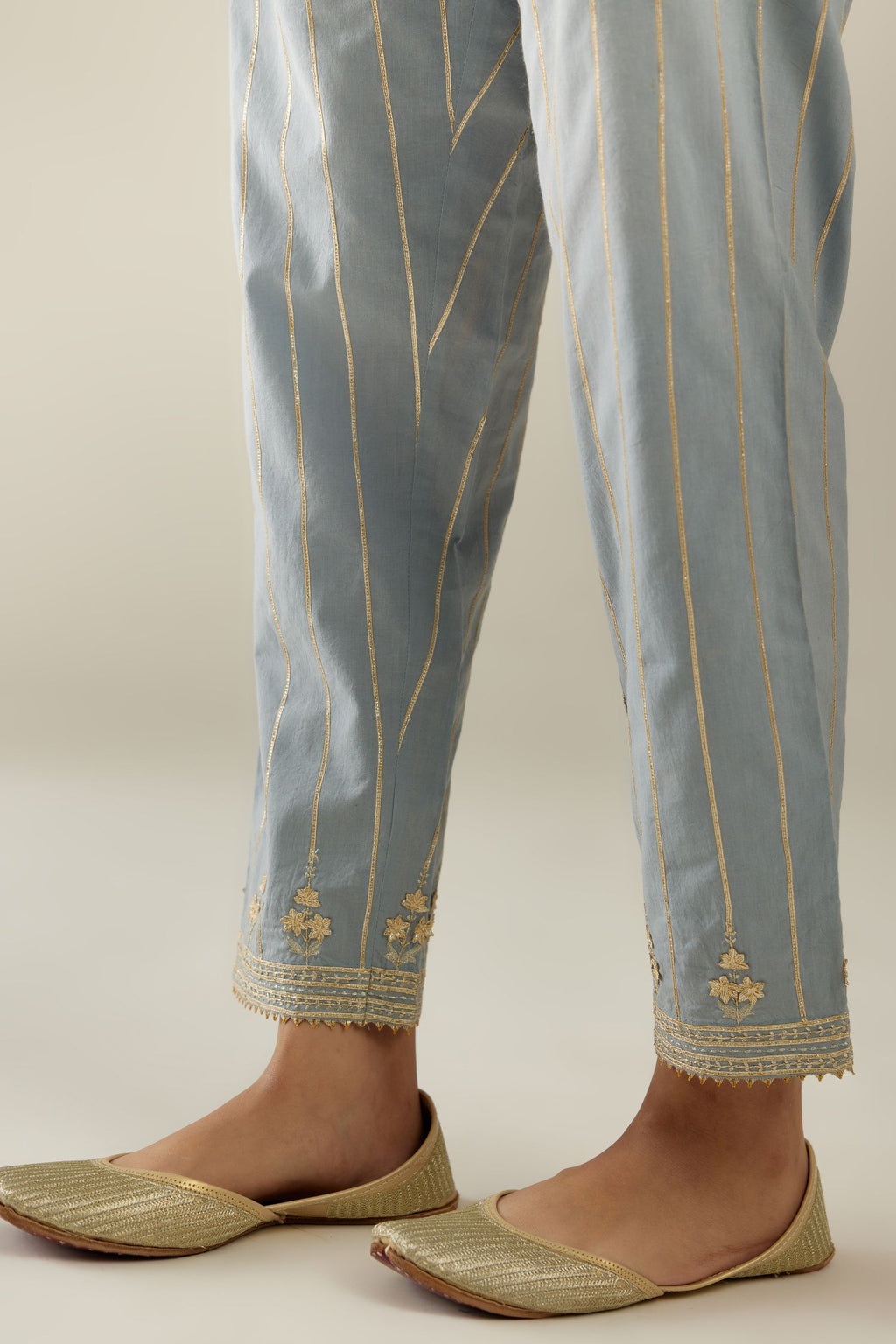 Blue cotton straight pants with all-over gold gota lines and zari embroidery at hem.
