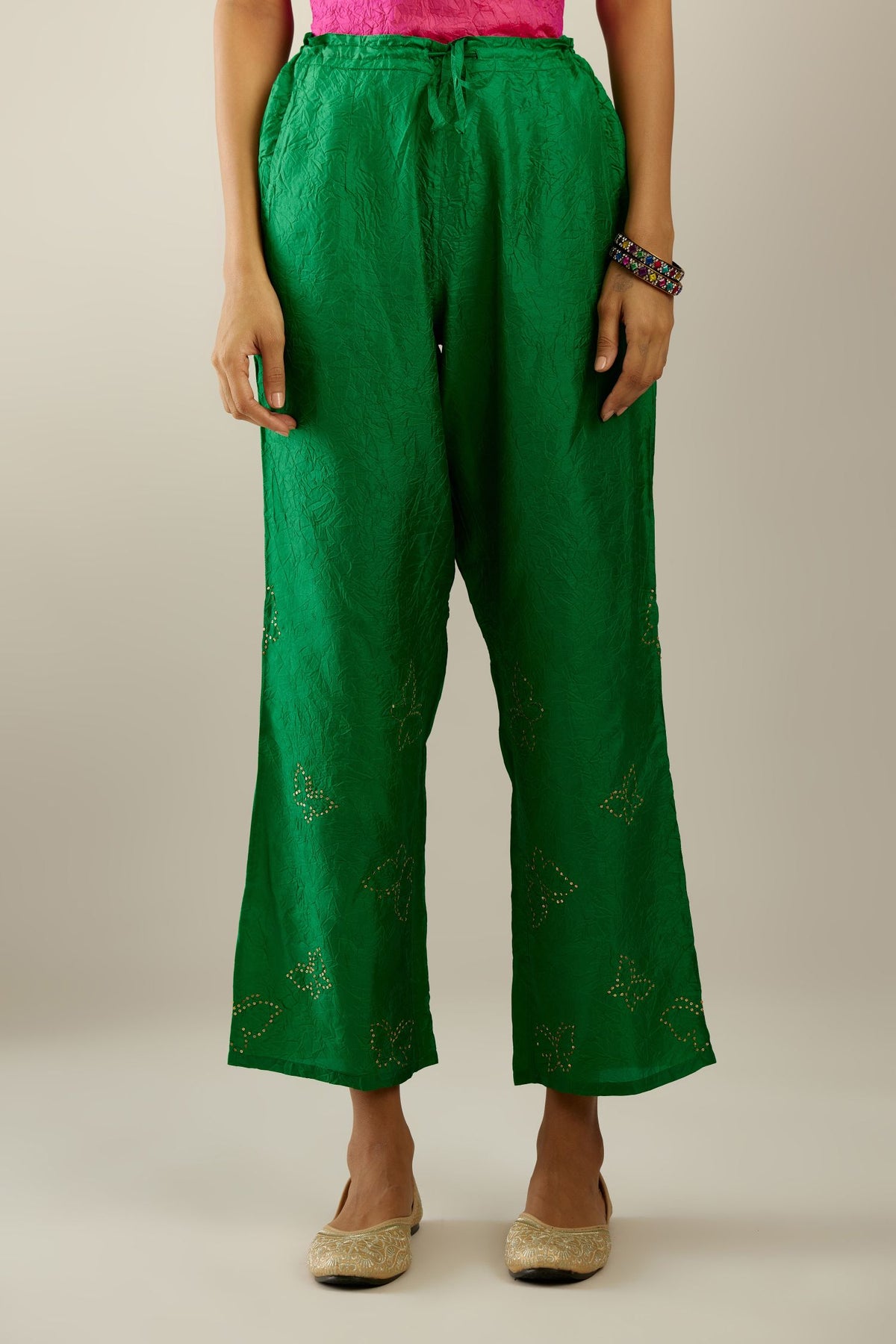 Grass green crushed silk pants with side pockets and assorted sequined butterflies till mid-calf length.