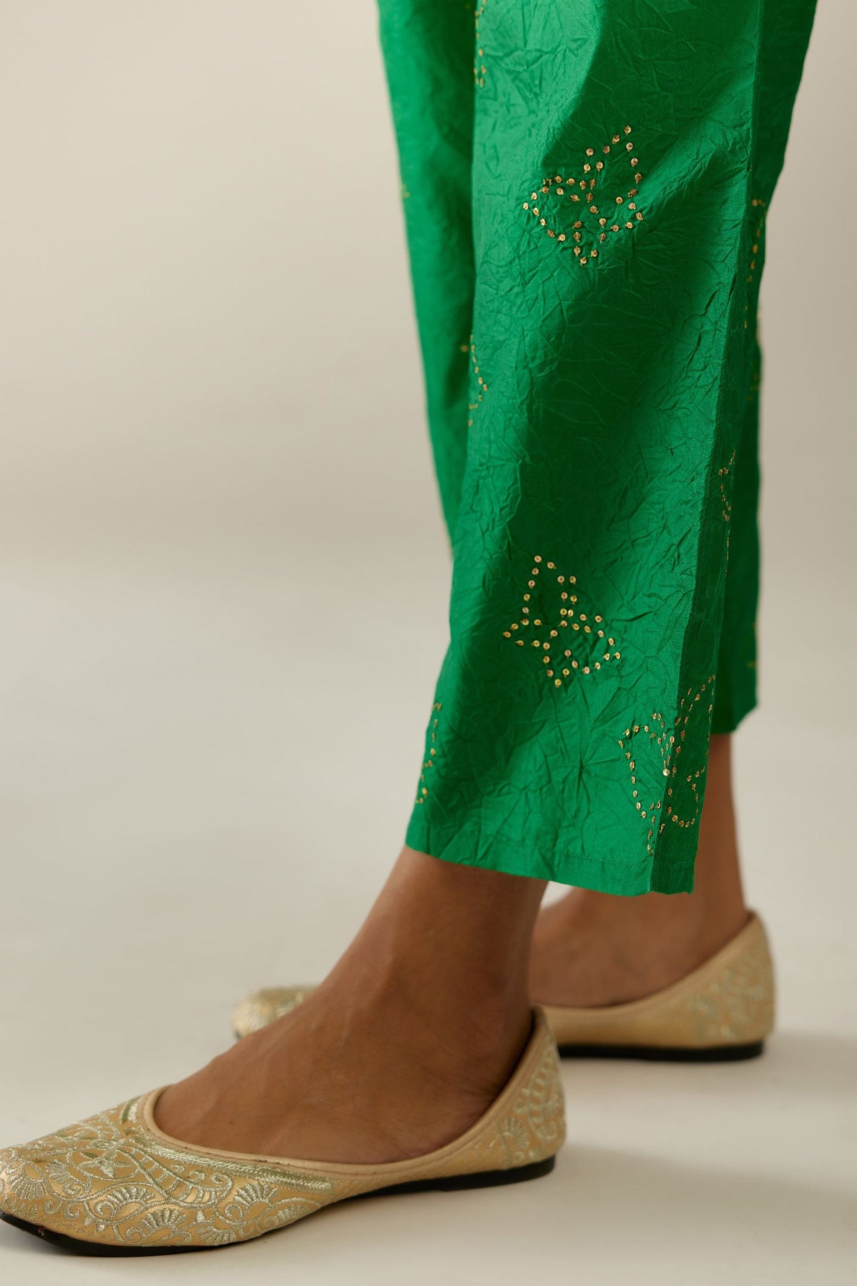 Grass green crushed silk pants with side pockets and assorted sequined butterflies till mid-calf length.