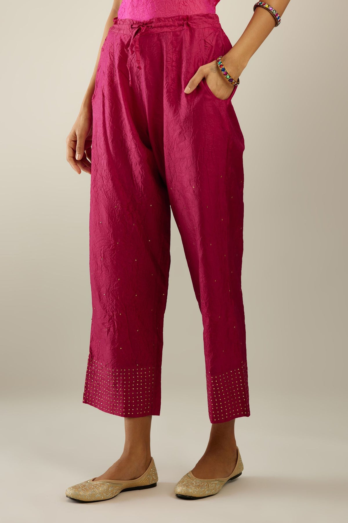 Jazzberry jam hand crushed silk straight pants detailed with gold sequins at hem and a single sequin buti is sprayed all over the pants and side pockets