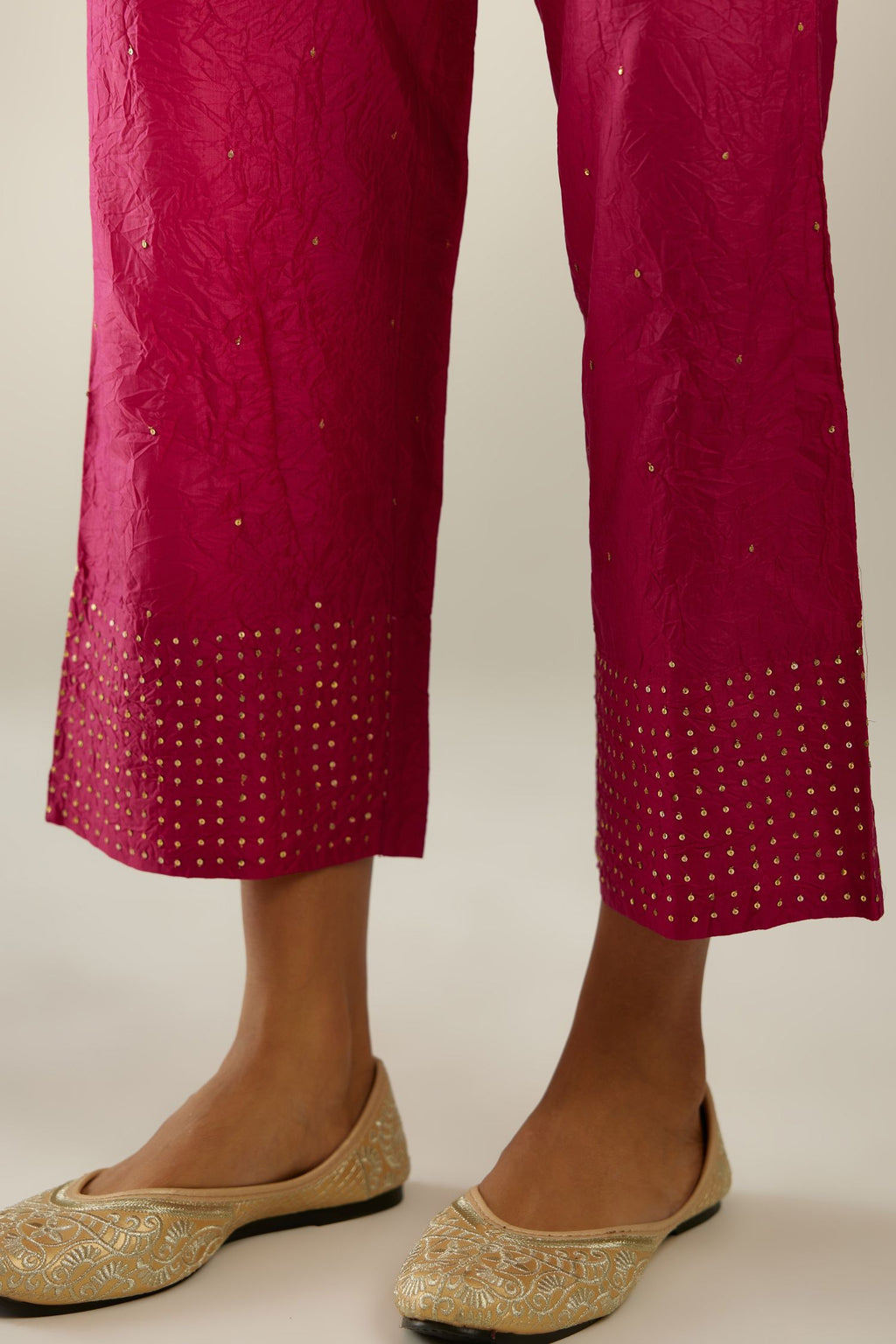 Jazzberry jam hand crushed silk straight pants detailed with gold sequins at hem and a single sequin buti is sprayed all over the pants and side pockets